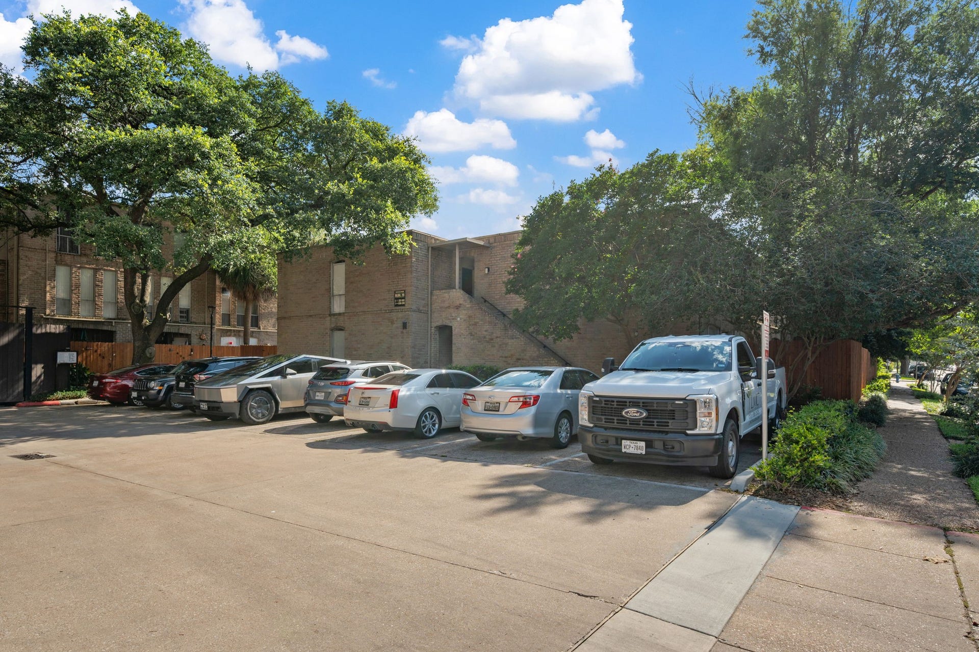 4649 Wild Indigo Street, #337, Houston, TX 77027 Ample parking space nestled under mature trees, offering shade and convenience in a serene neighborhood setting.
