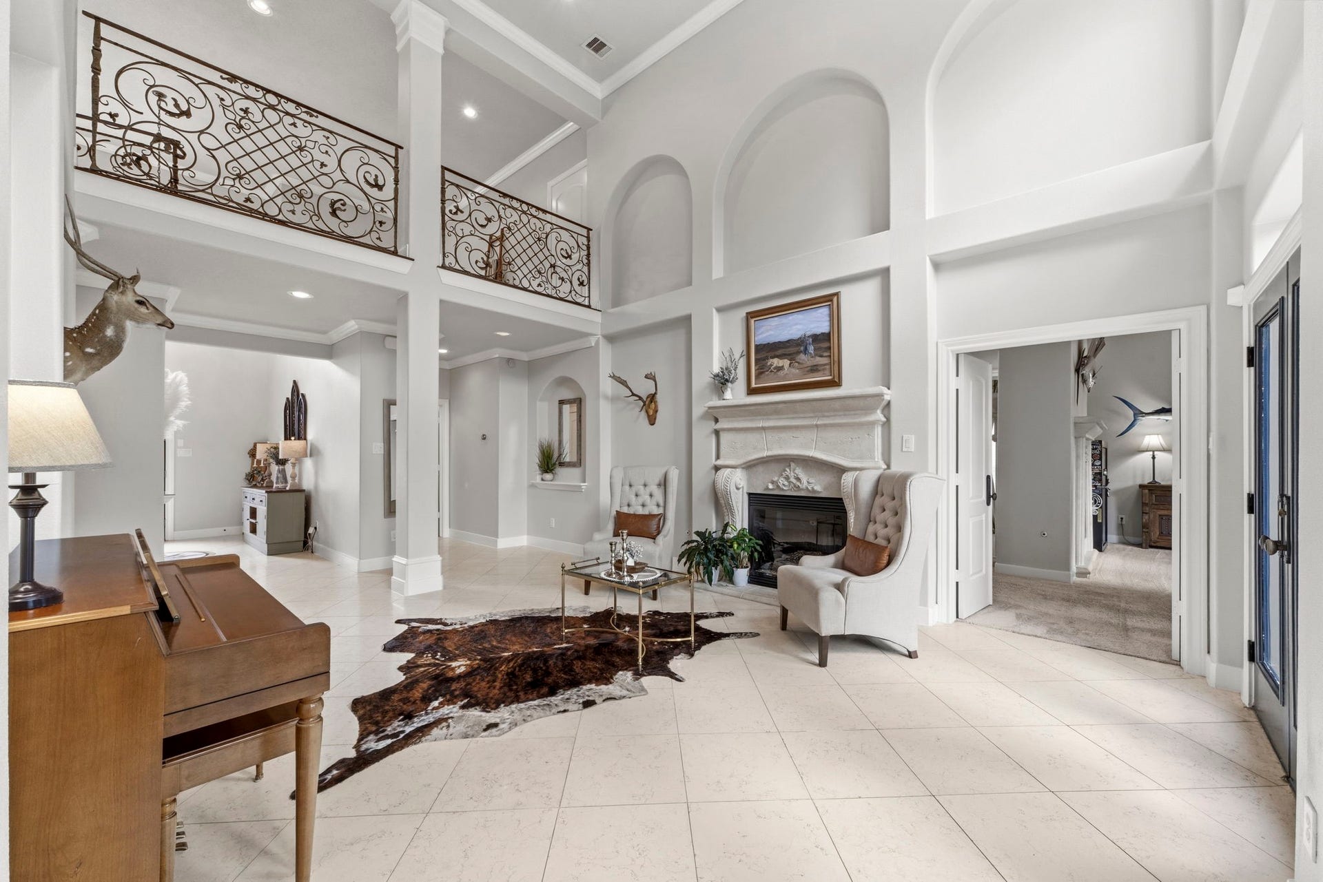 4903 Westerdale Drive, Fulshear, TX 77441 Rich marble tile flooring enhances the elegance of the formal living room. The private first-floor primary suite awaits just beyond the double doorway on the right.