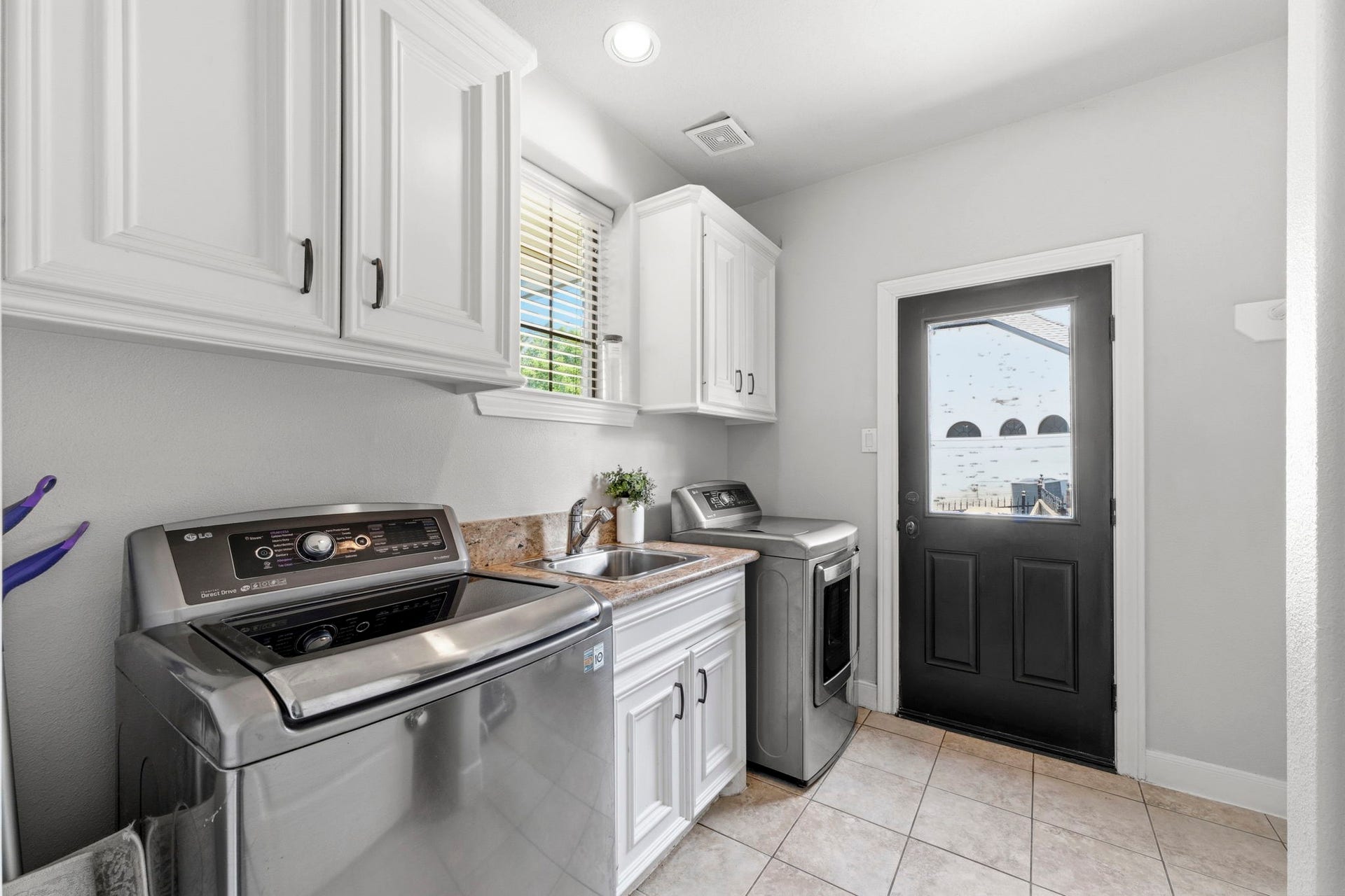 4903 Westerdale Drive, Fulshear, TX 77441 Spacious utility room offers abundant cabinetry, a utility sink, room for a second refrigerator, and direct access to a side patio.