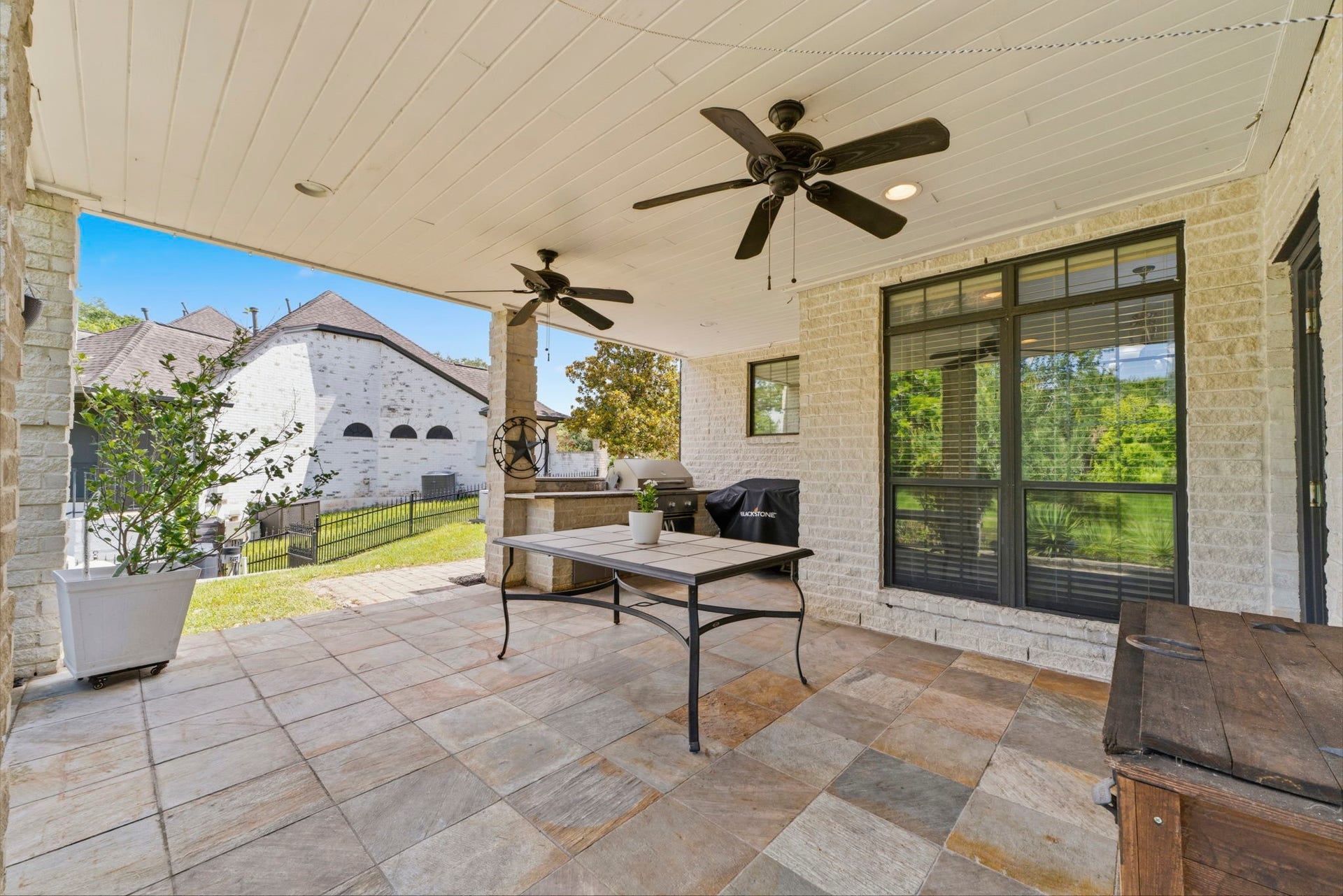 4903 Westerdale Drive, Fulshear, TX 77441 Covered patio with outdoor kitchen, two ceiling fans, and plenty of room for year-round entertaining.