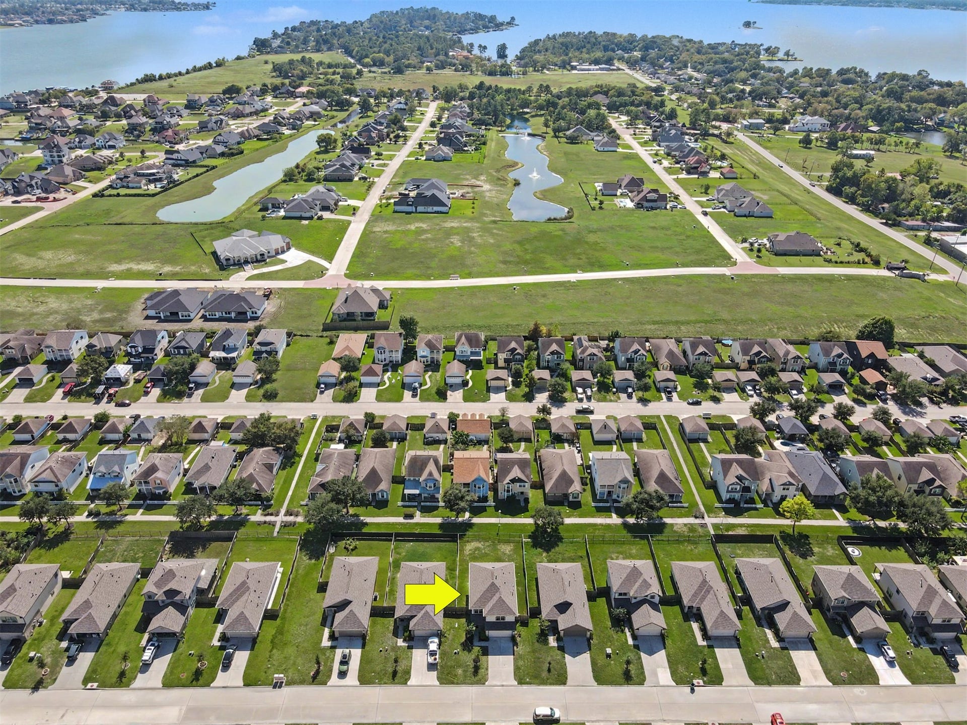 Aerial view highlighting the home's location within the neighborhood, with scenic water features and beautiful Lake Conroe nearby.