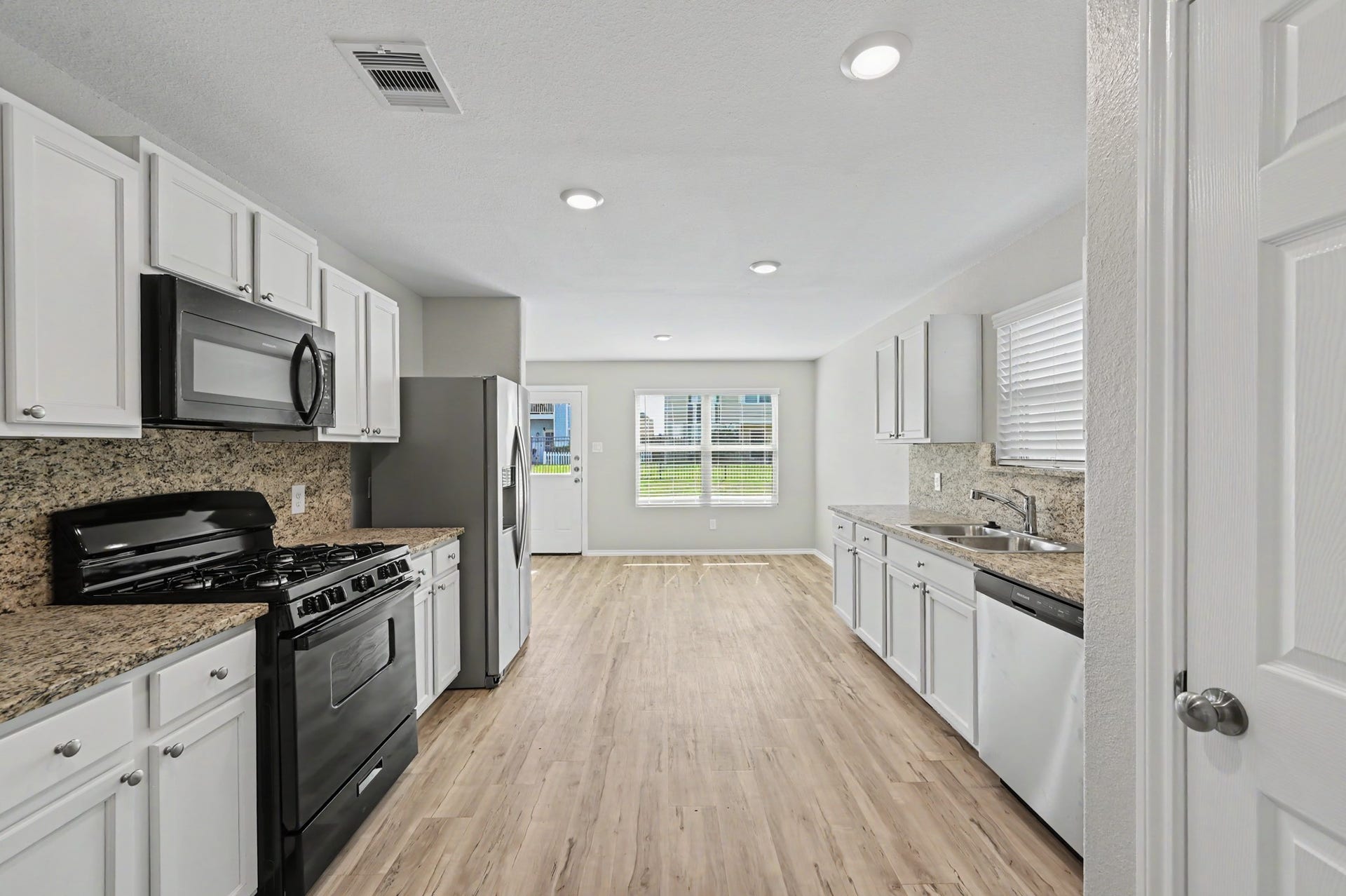Another view of the spacious kitchen and adjoining dining area overlooking the backyard.