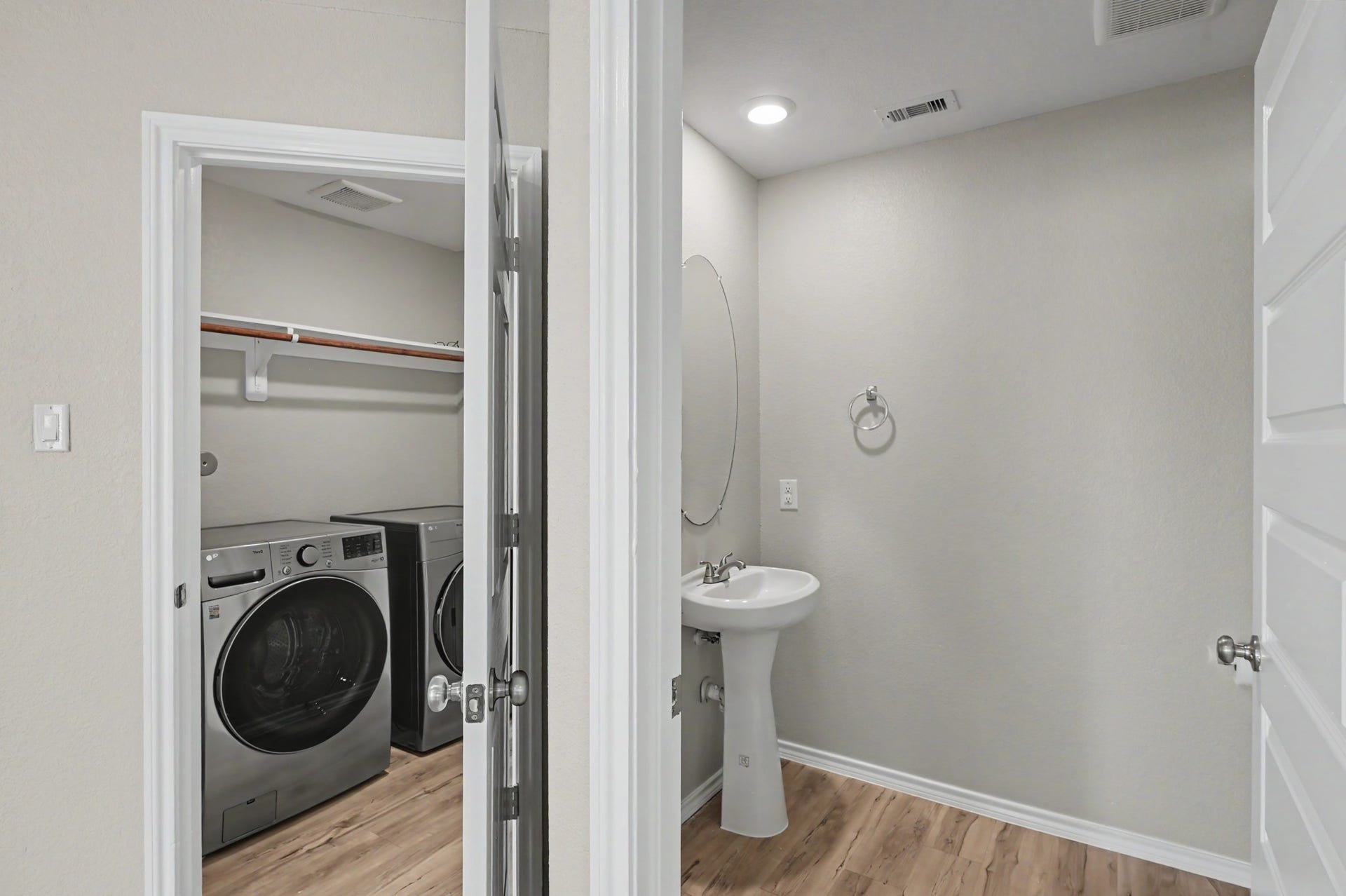 Convenient downstairs laundry room and adjacent half bath with pedestal sink.
