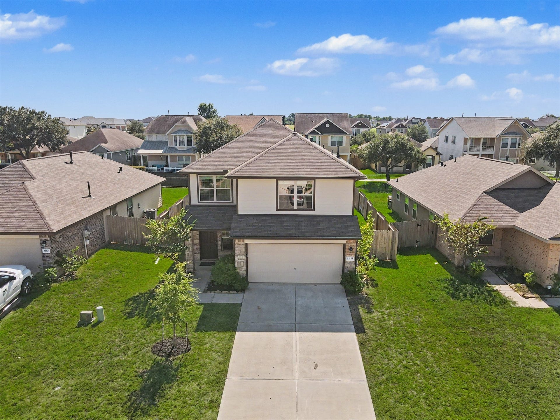 Aerial view showcasing this beautiful two-story home with attractive curb appeal, landscaped front yard, spacious driveway, and attached 2-car garage in the gated Lake Breeze community!