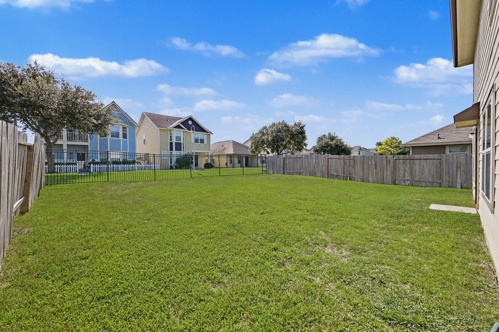 Another view of the spacious, fully fenced backyard offering plenty of room for outdoor activities and entertaining, with no immediate rear neighbors and a walking trail beyond the fence.