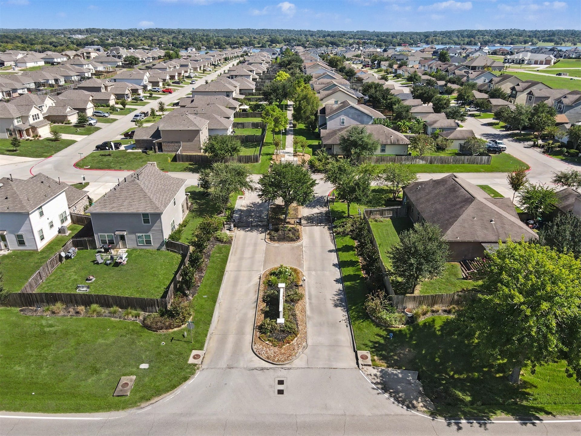 Aerial view of the gated entrance to Lake Breeze, a welcoming community featuring beautifully maintained grounds, tree-lined streets, and convenient access to Lake Conroe!