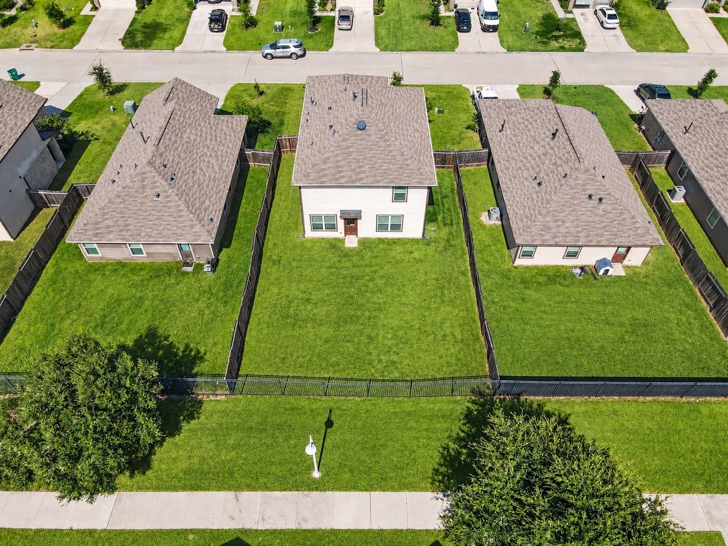 Aerial view showcasing the spacious backyard with plenty of green space for outdoor activities, entertaining, or simply relaxing. Fully fenced backyard with no immediate rear neighbors and a walking trail conveniently located behind the property! Virtually staged greener grass.