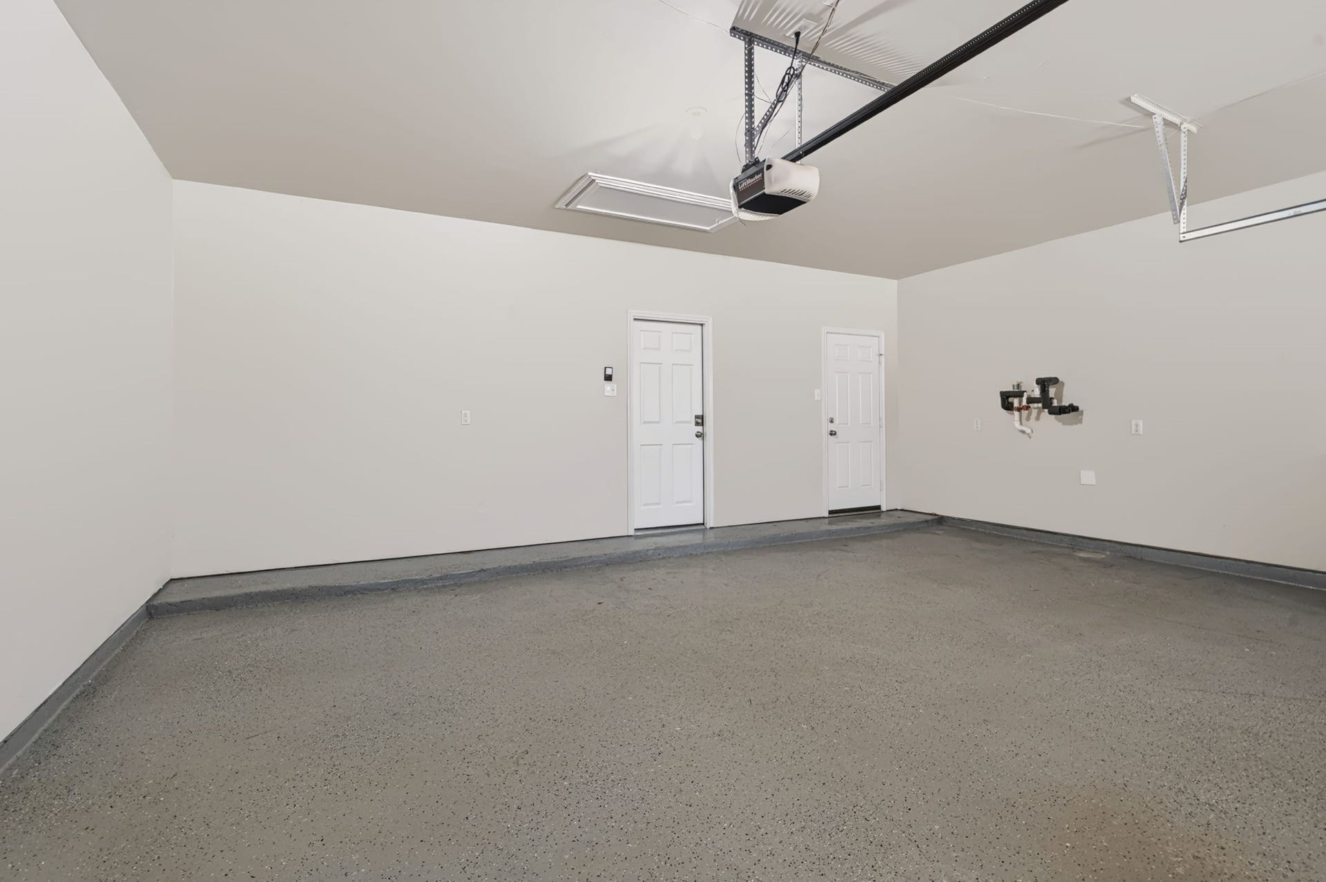 314 Trillium Drive, Sugar Land, TX 77479 Spacious 2.5-car garage featuring an epoxy-coated floor, a pull-down attic ladder for additional storage, and an existing hookup for a water softener.
