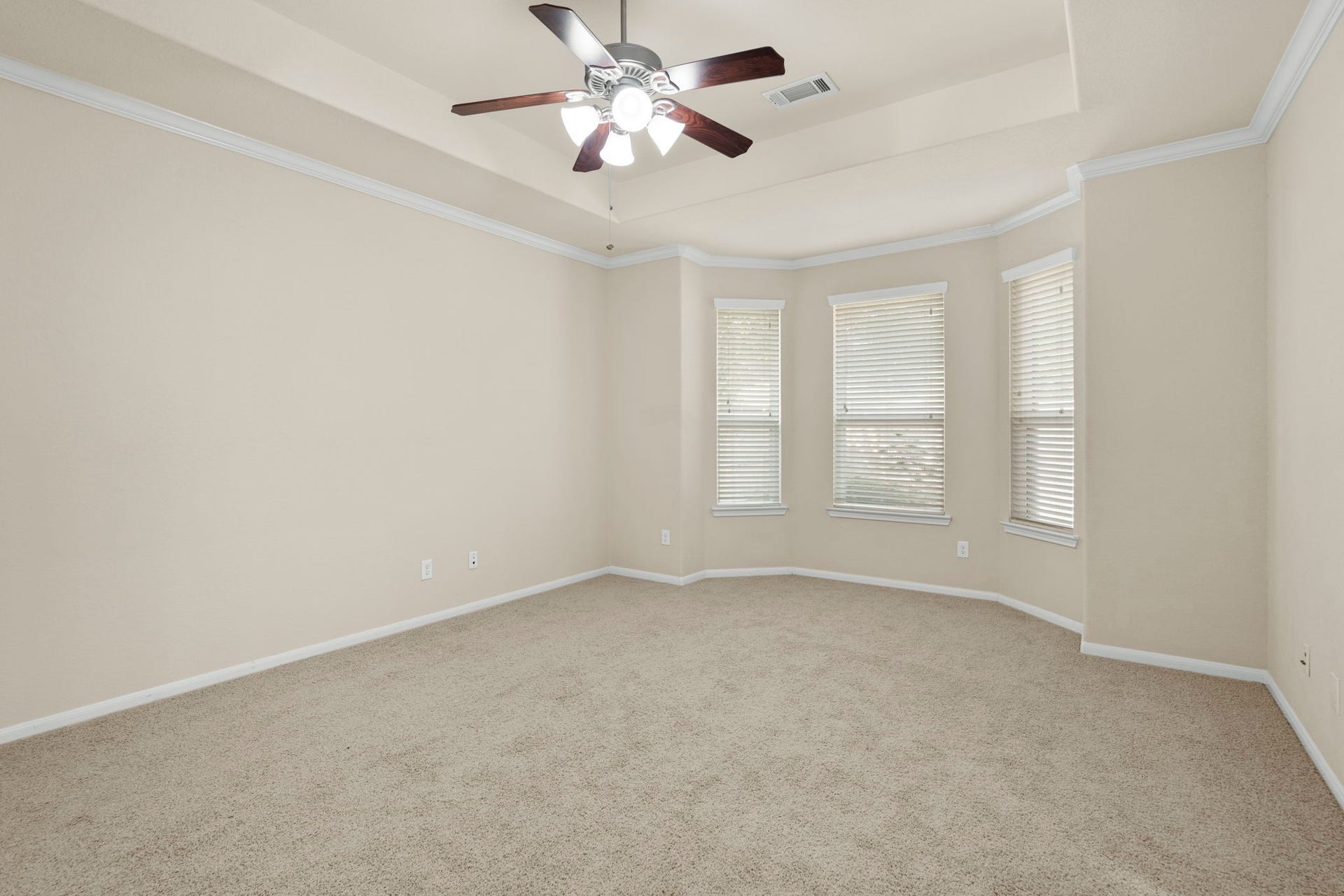 314 Trillium Drive, Sugar Land, TX 77479 The primary suite features a dramatic recessed ceiling, lighted ceiling fan, bay of three windows overlooking the private backyard, and an en suite bathroom.
