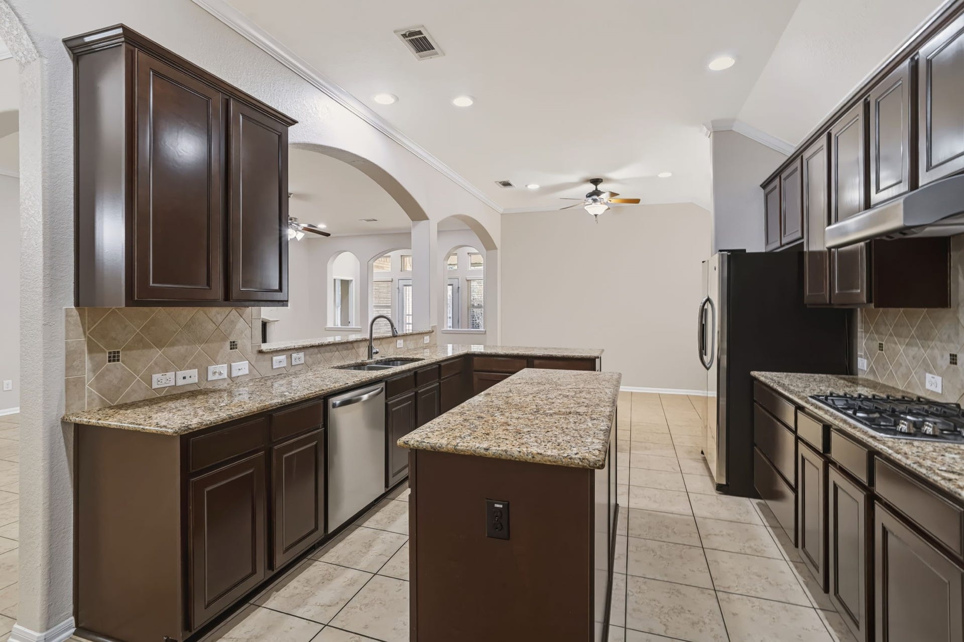 314 Trillium Drive, Sugar Land, TX 77479 Center island with granite countertops, tile backsplash, and abundant counter space and cabinetry, offer ample storage and a functional layout for meal preparation.
