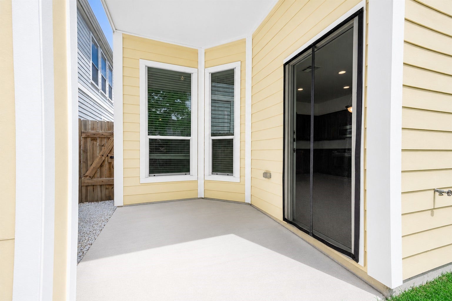 14923 ATMORE Place Dr, Houston, TX 77082 This covered patio area allows access into the home interiors through a sliding glass door. 2 large windows provide interiors with natural light. Virtually staged to inspire design possibilities