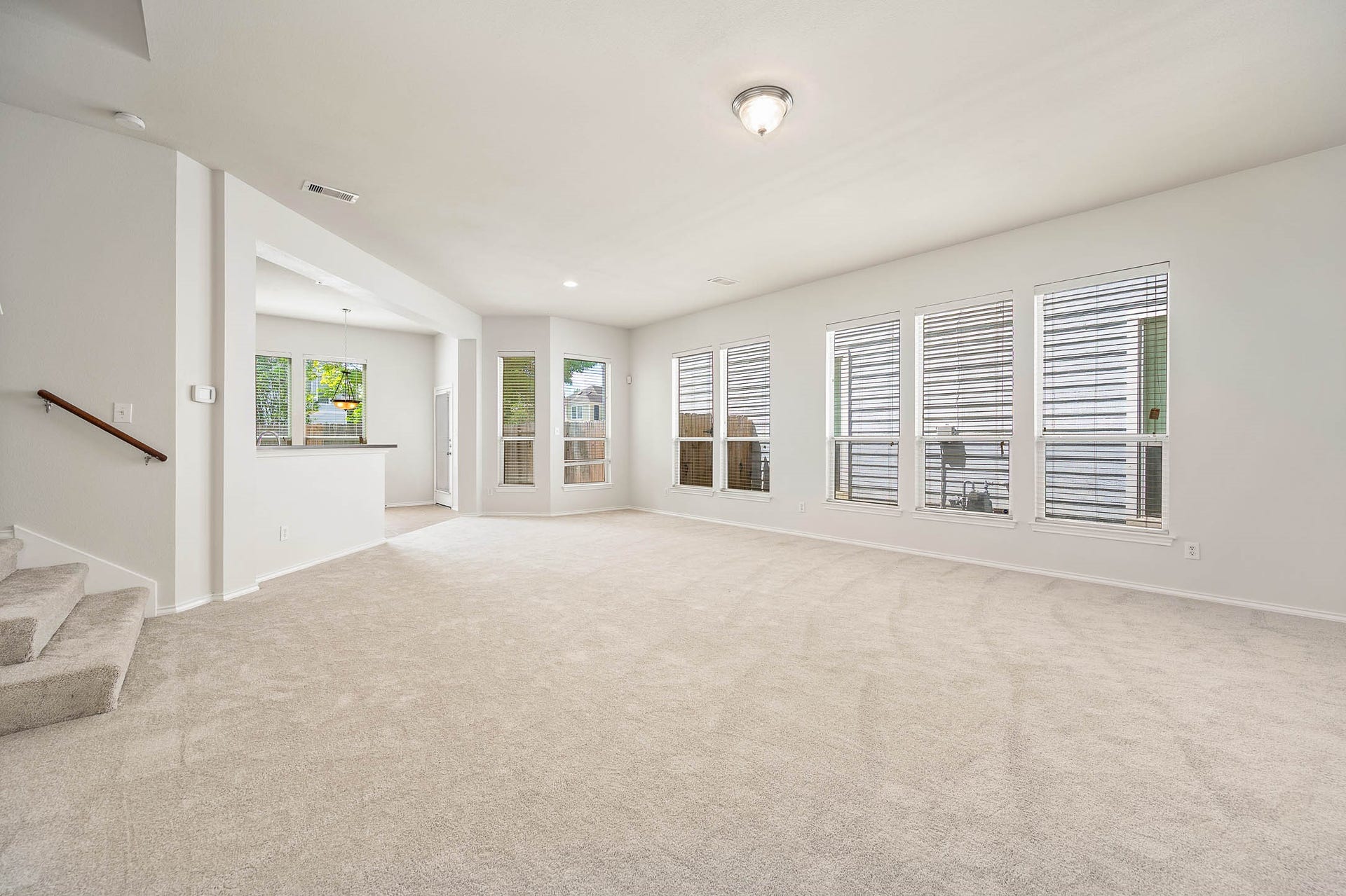 14923 ATMORE Place Dr, Houston, TX 77082 Spacious living area features new neutral color carpeting, ample natural light from multiple windows, and an open floor plan leading to the kitchen/dining, Ideal for family gatherings and entertaining.