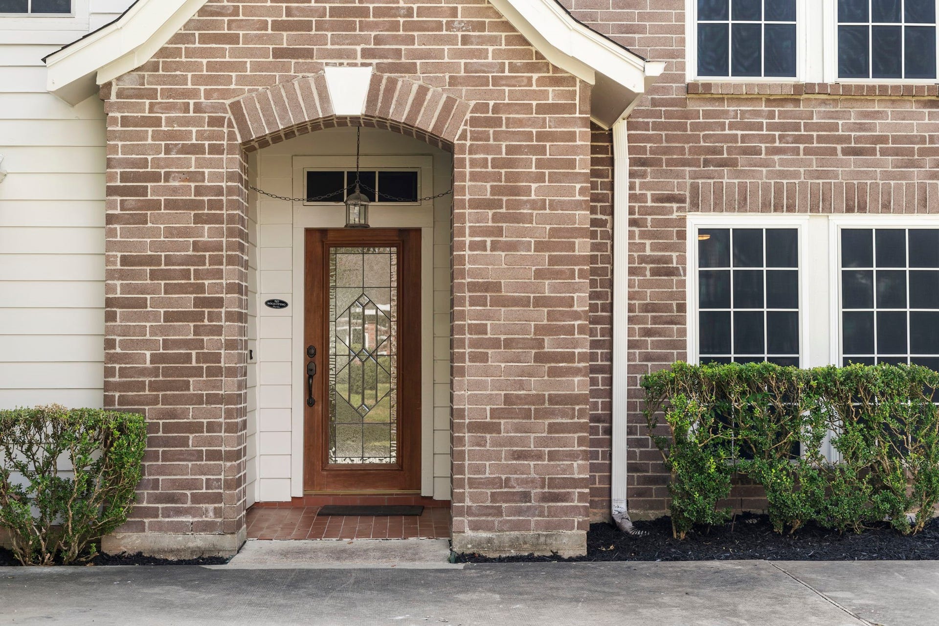 2915 Cane Field Drive, Sugar Land, TX 77479 A covered brick entry & warm wood front door create an inviting welcome, setting the tone for the homes classic style.