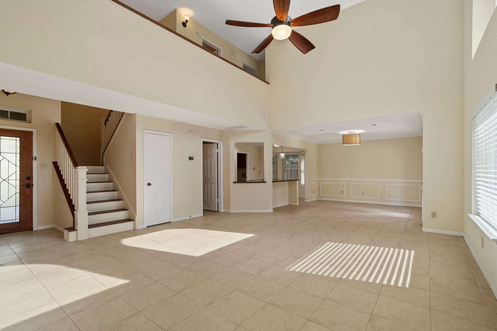 2915 Cane Field Drive, Sugar Land, TX 77479 A spacious, light-filled living area features a dramatic two-story ceiling & an open layout that flows easily into the dining area & kitchen.