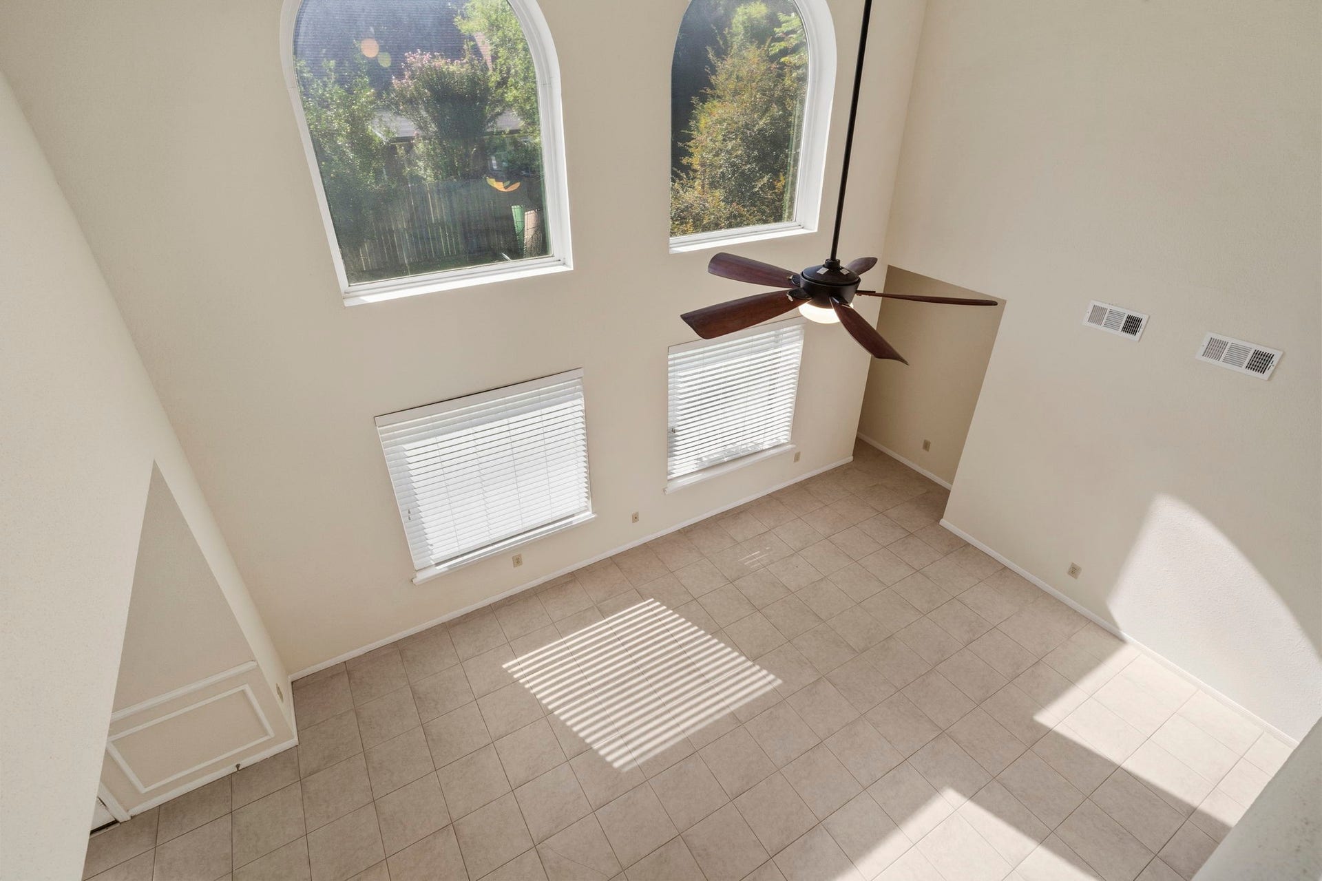 2915 Cane Field Drive, Sugar Land, TX 77479 The dramatic two-story living room is filled with natural light from oversized arched windows.