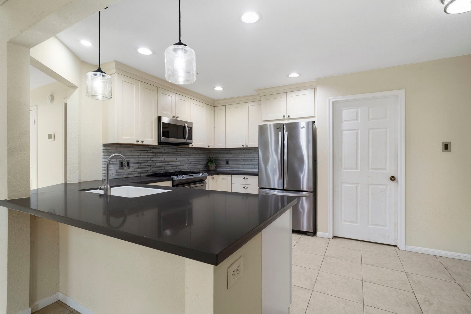 2915 Cane Field Drive, Sugar Land, TX 77479 A closer look at the kitchen highlights the expansive breakfast bar, sleek countertops & abundant cabinetry, providing plenty of prep space & casual seating.