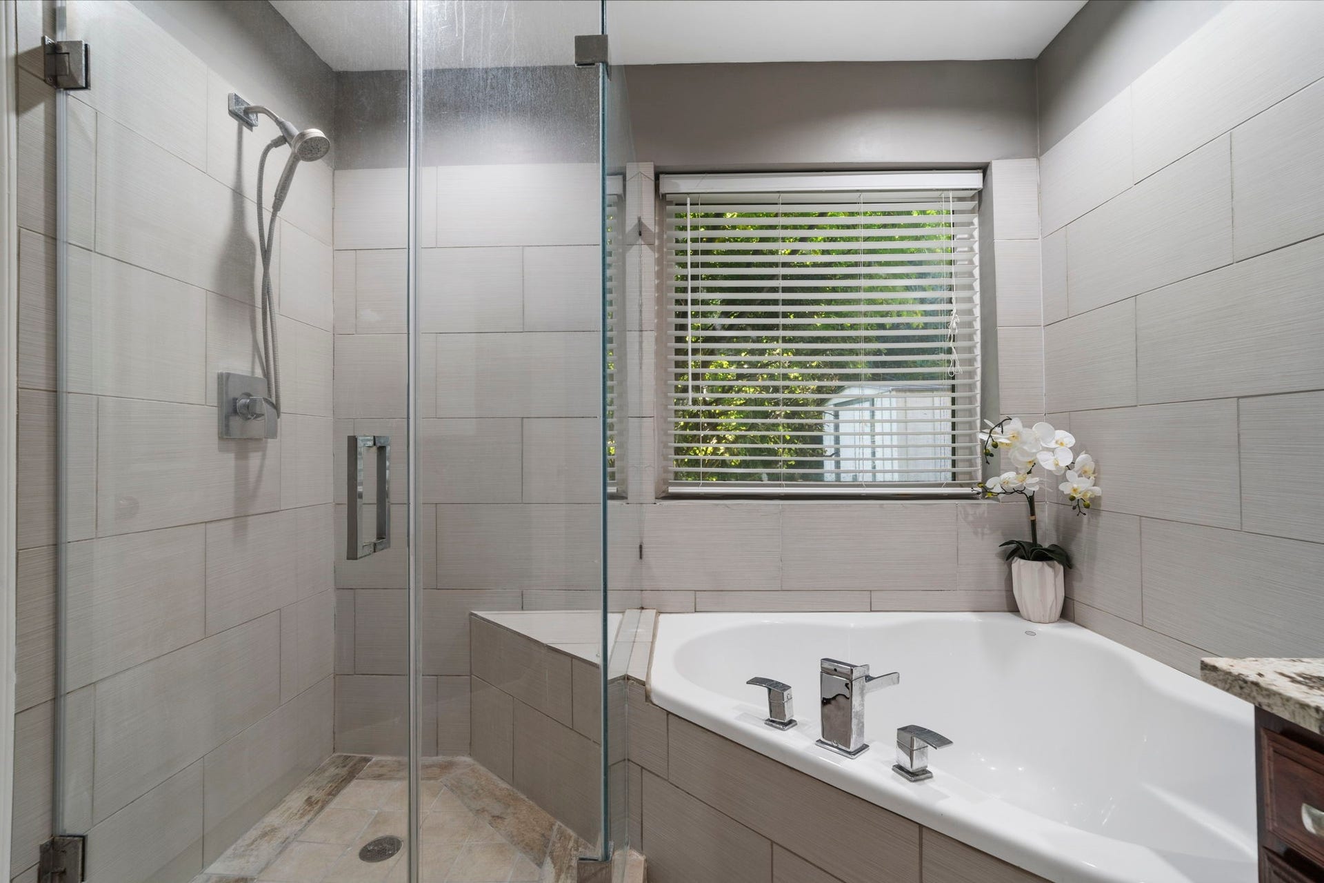 2915 Cane Field Drive, Sugar Land, TX 77479 A frameless glass shower with floor-to-ceiling tile sits alongside the soaking tub, creating a clean & updated primary bath.