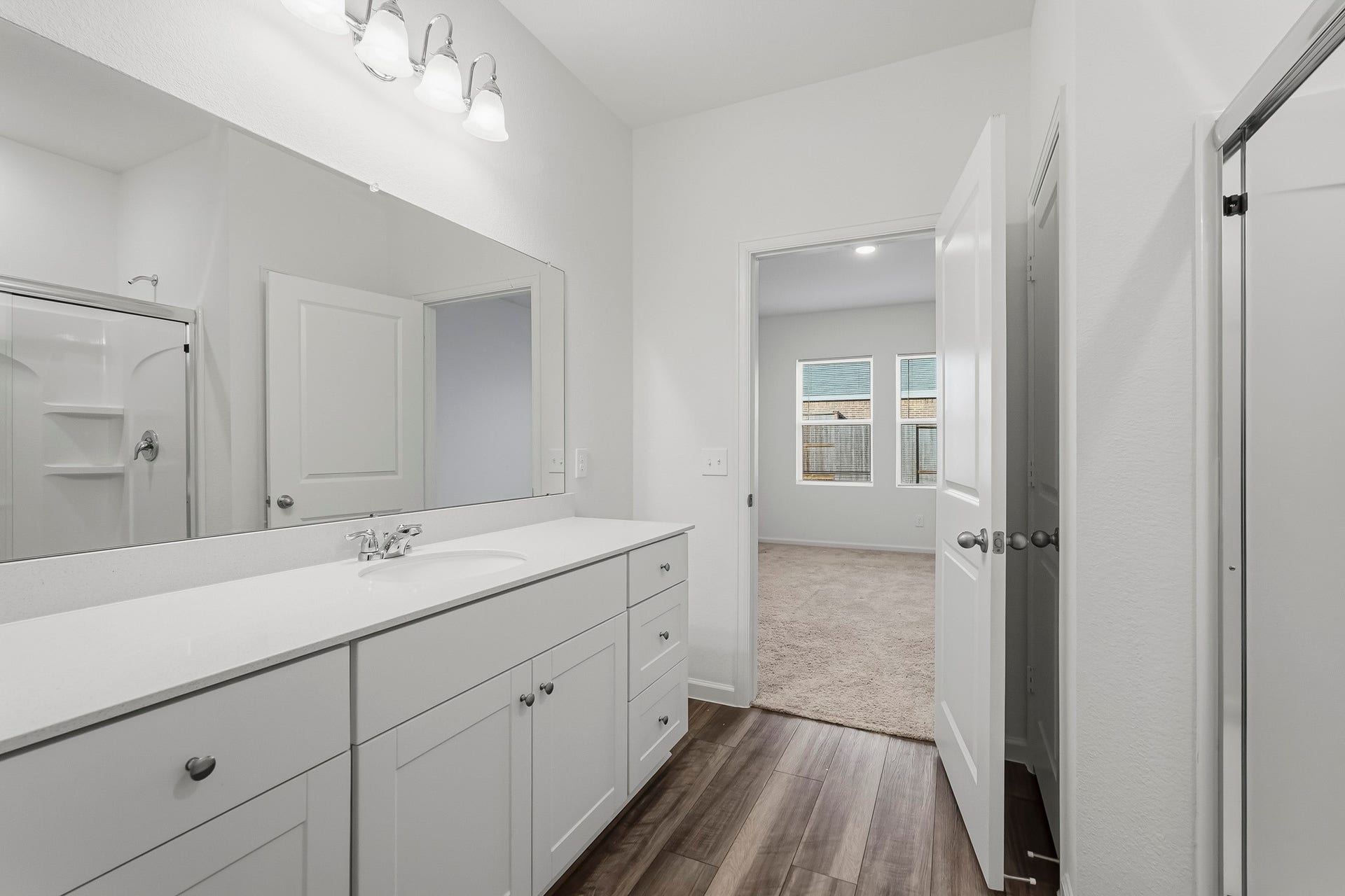 21547 Rolling Streams Drive, New Caney, TX 77357 An impressive oversized wall-mounted mirror extends across the vanity, enhancing the room's open and airy atmosphere.