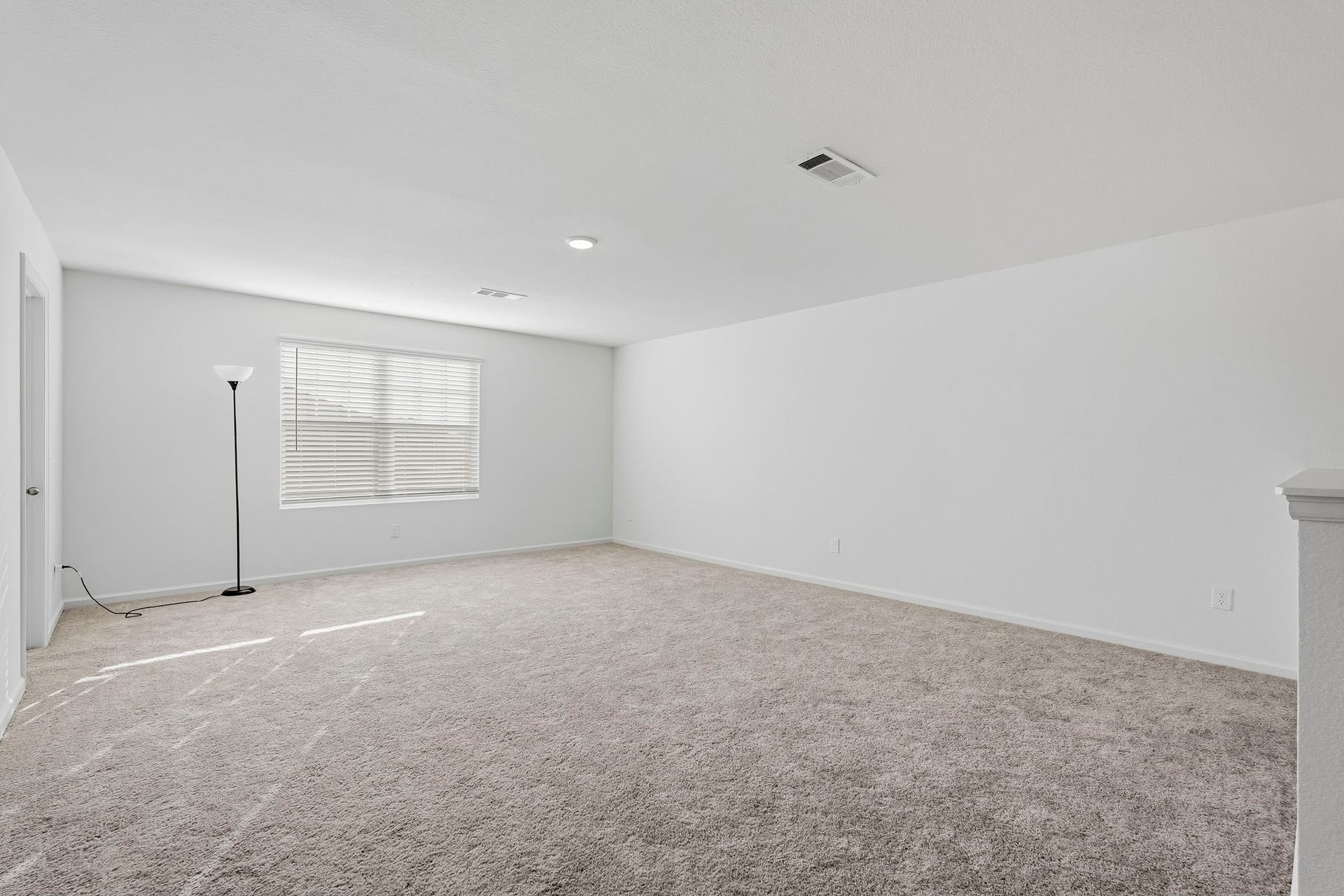 21547 Rolling Streams Drive, New Caney, TX 77357 This expansive upstairs game room offers an incredible flexible living space, perfect for entertainment, recreation, or everyday relaxation. Featuring a spacious open layout, plush neutral carpeting, crisp white walls, and recessed ceiling lighting, the room provides a bright and welcoming atmosphere. A large window with adjustable blinds allows natural light to fill the space, enhancing its airy feel.
