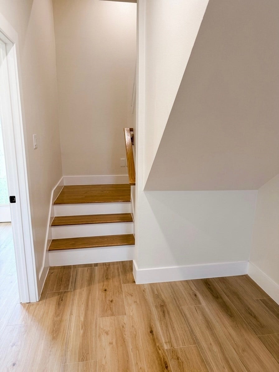 102 Sylvester Road, #C, Houston, TX 77009 Charming staircase with warm porcelain flooring and clean white walls, offering a modern and inviting entrance.