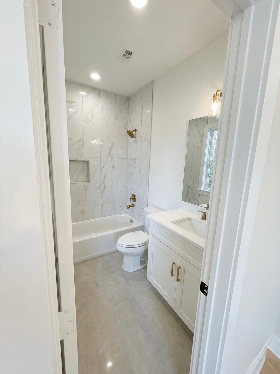 102 Sylvester Road, #C, Houston, TX 77009 Elegant bathroom featuring a sleek marble-tiled shower, modern fixtures, and a stylish vanity for a touch of luxury.