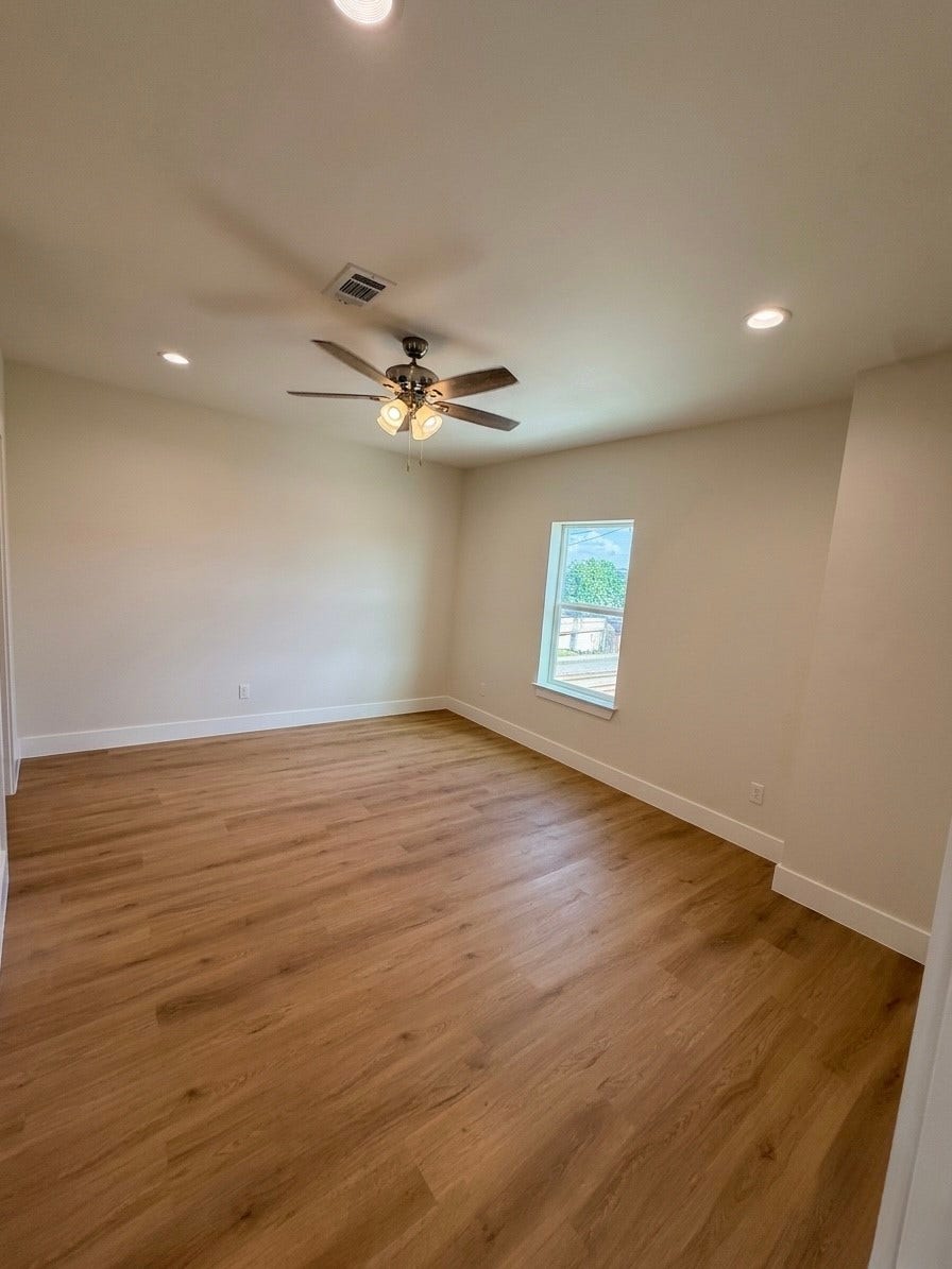 102 Sylvester Road, #C, Houston, TX 77009 Bright and airy room featuring engineered hardwood floors, recessed lighting, and a ceiling fan for comfort.