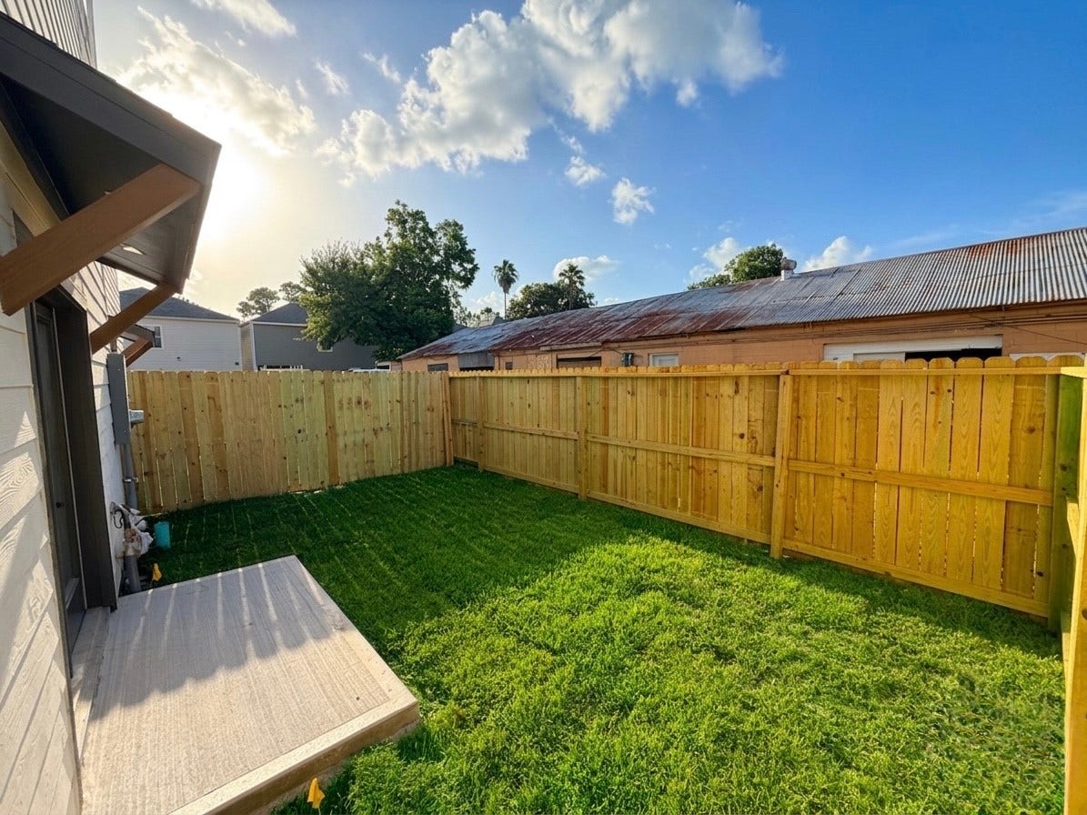 102 Sylvester Road, #C, Houston, TX 77009 Charming backyard with a privacy fence and lush green lawn, perfect for outdoor relaxation and entertaining.