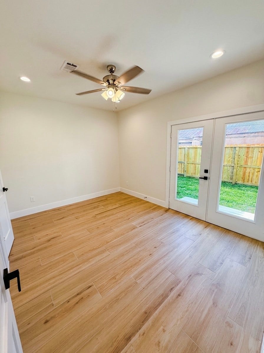 102 Sylvester Road, #C, Houston, TX 77009 Bright and inviting room on 1st story with elegant porcelain flooring, a ceiling fan, and French doors opening to a private fenced yard.
