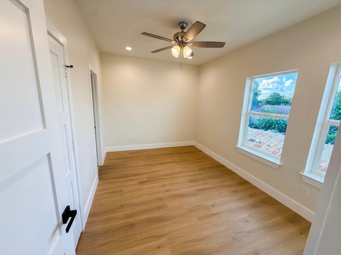 102 Sylvester Road, #C, Houston, TX 77009 Bright and inviting room featuring sleek hardwood engineered floors, a modern ceiling fan, and large windows offering scenic views.