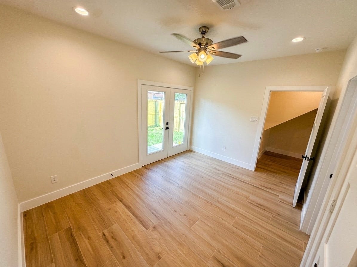 102 Sylvester Road, #C, Houston, TX 77009 Bright and inviting room with porcelain flooring, and double doors opening to a private backyard, perfect for relaxation or entertaining.