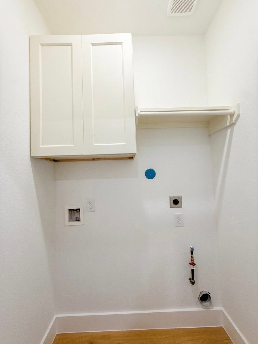 102 Sylvester Road, #C, Houston, TX 77009 Compact laundry area with hookups, featuring upper cabinetry and a convenient hanging rod for additional storage.