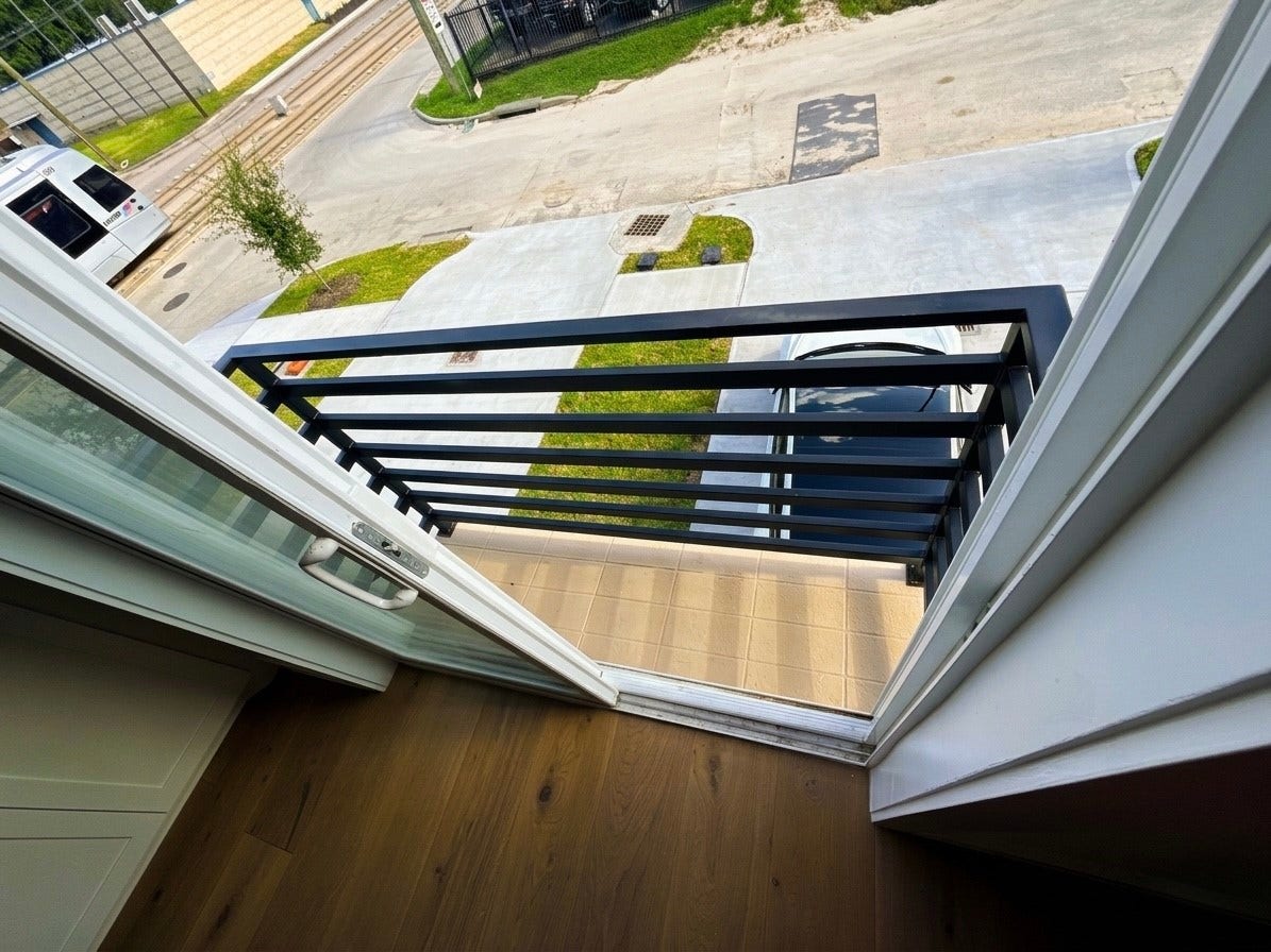 102 Sylvester Road, #C, Houston, TX 77009 Charming balcony with sleek black railings offers a cozy outdoor space overlooking street.