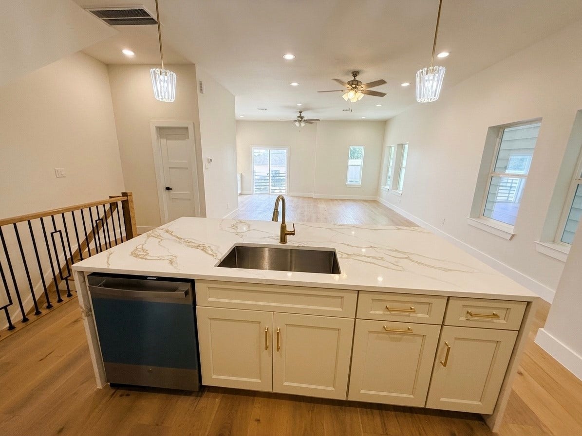 102 Sylvester Road, #C, Houston, TX 77009 Bright and spacious open-concept living area featuring a stylish kitchen island with elegant countertops, modern fixtures, and ample natural light from multiple windows.