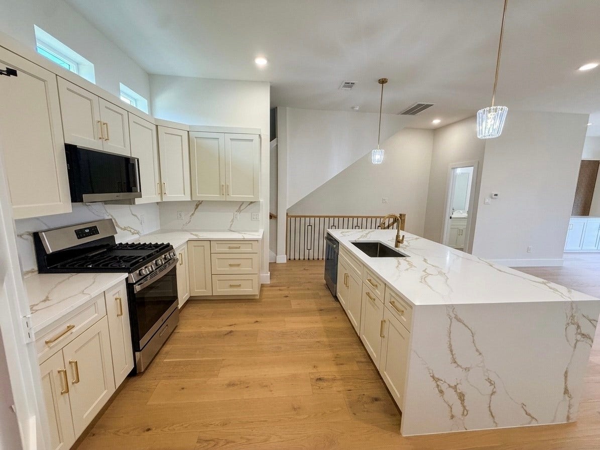102 Sylvester Road, #C, Houston, TX 77009 Bright and spacious kitchen featuring elegant quartz countertops, modern cabinetry, and stainless steel appliances, perfect for culinary enthusiasts.