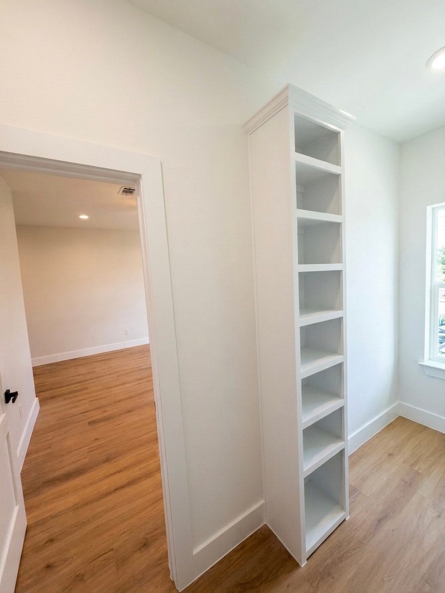 102 Sylvester Road, #C, Houston, TX 77009 Bright room featuring sleek engineered wooden floors and a slim built-in shelving unit, ideal for display or storage.