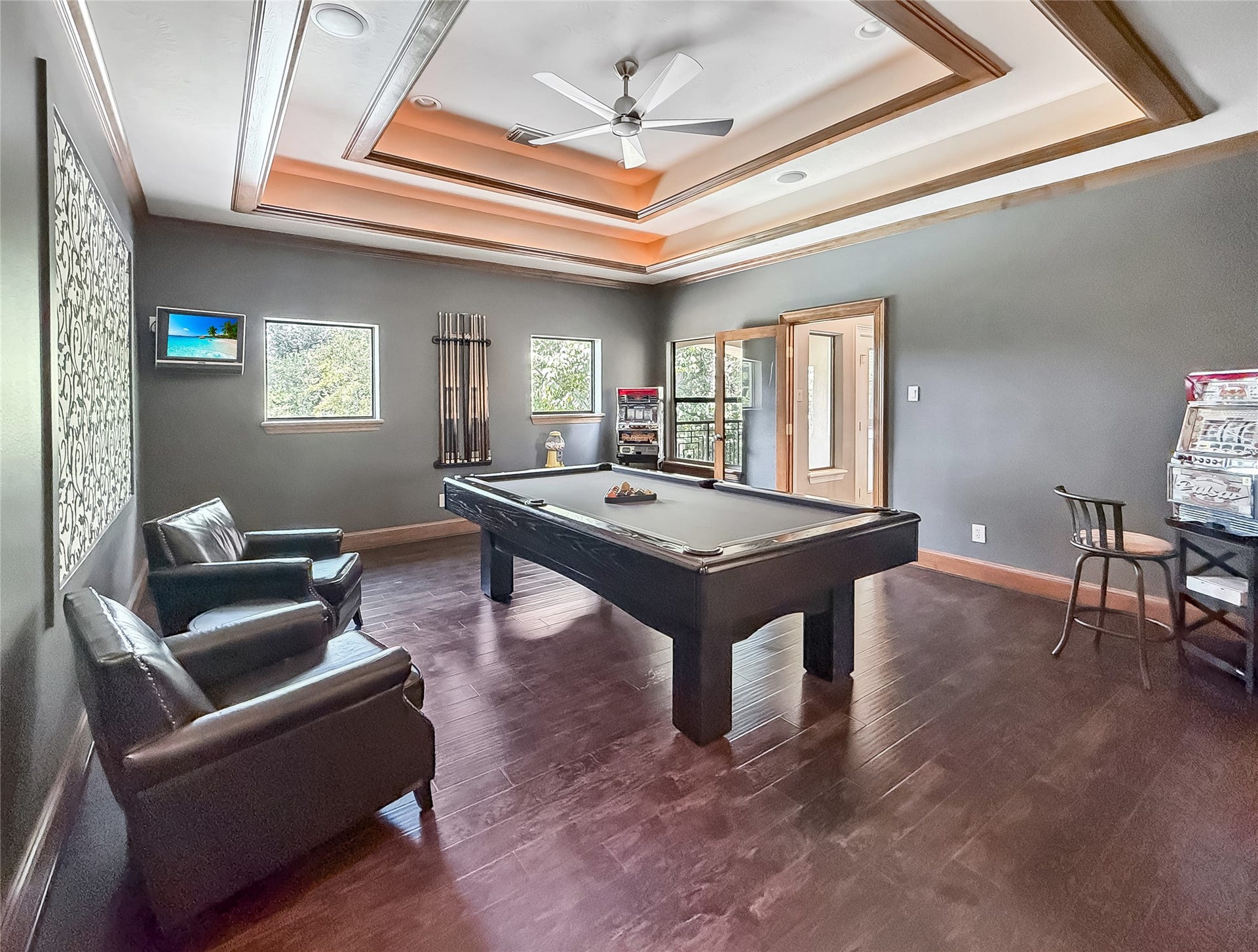 7611 Kings River Lane, Humble, TX 77346 Expansive game room features a dramatic tray ceiling with accent lighting, rich wood flooring, wet bar and ample space for billiards and additional seating.