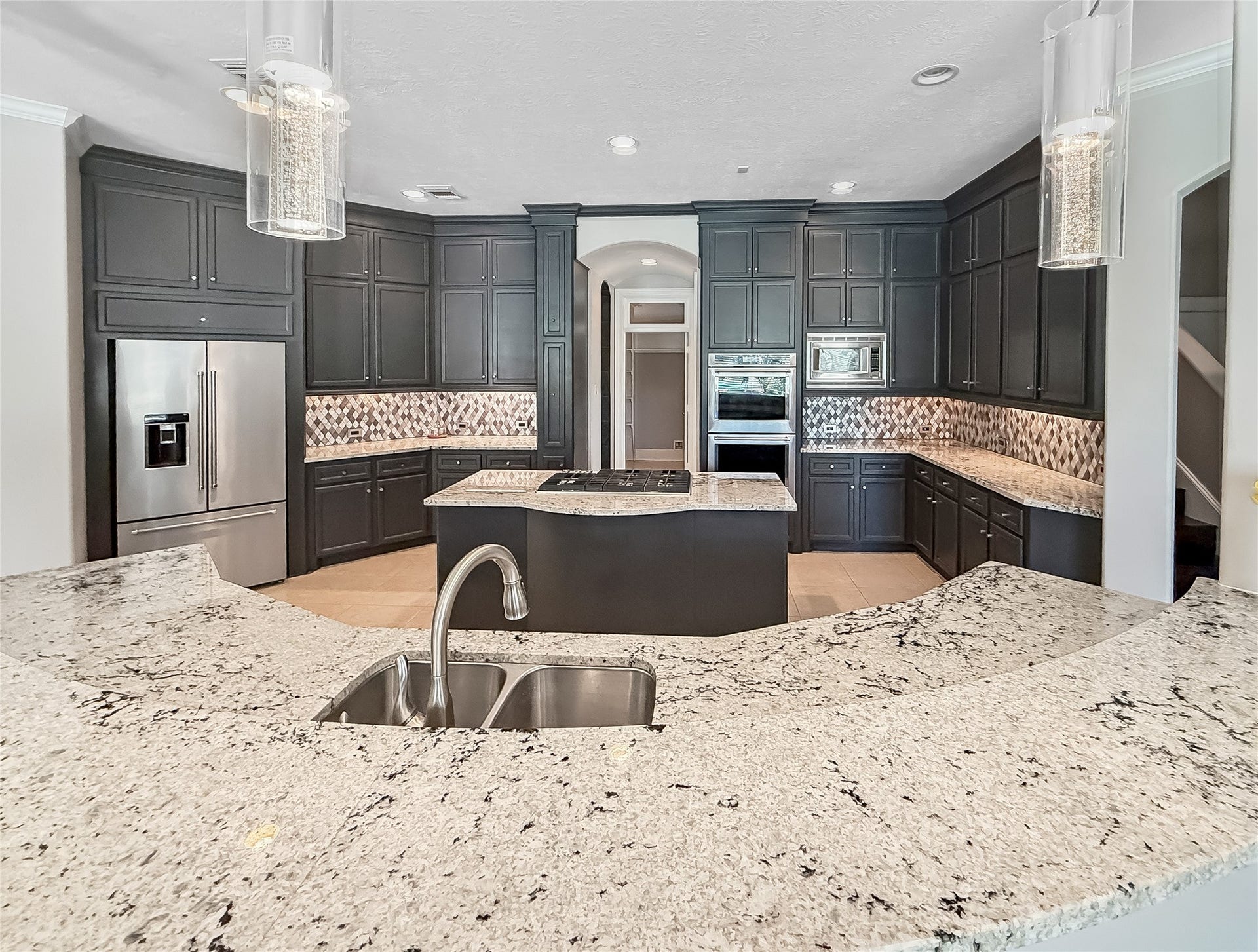 7611 Kings River Lane, Humble, TX 77346 Expansive center island provides abundant countertop space for food preparation, serving and casual gatherings, complemented by pendant lighting and additional cabinet storage below.