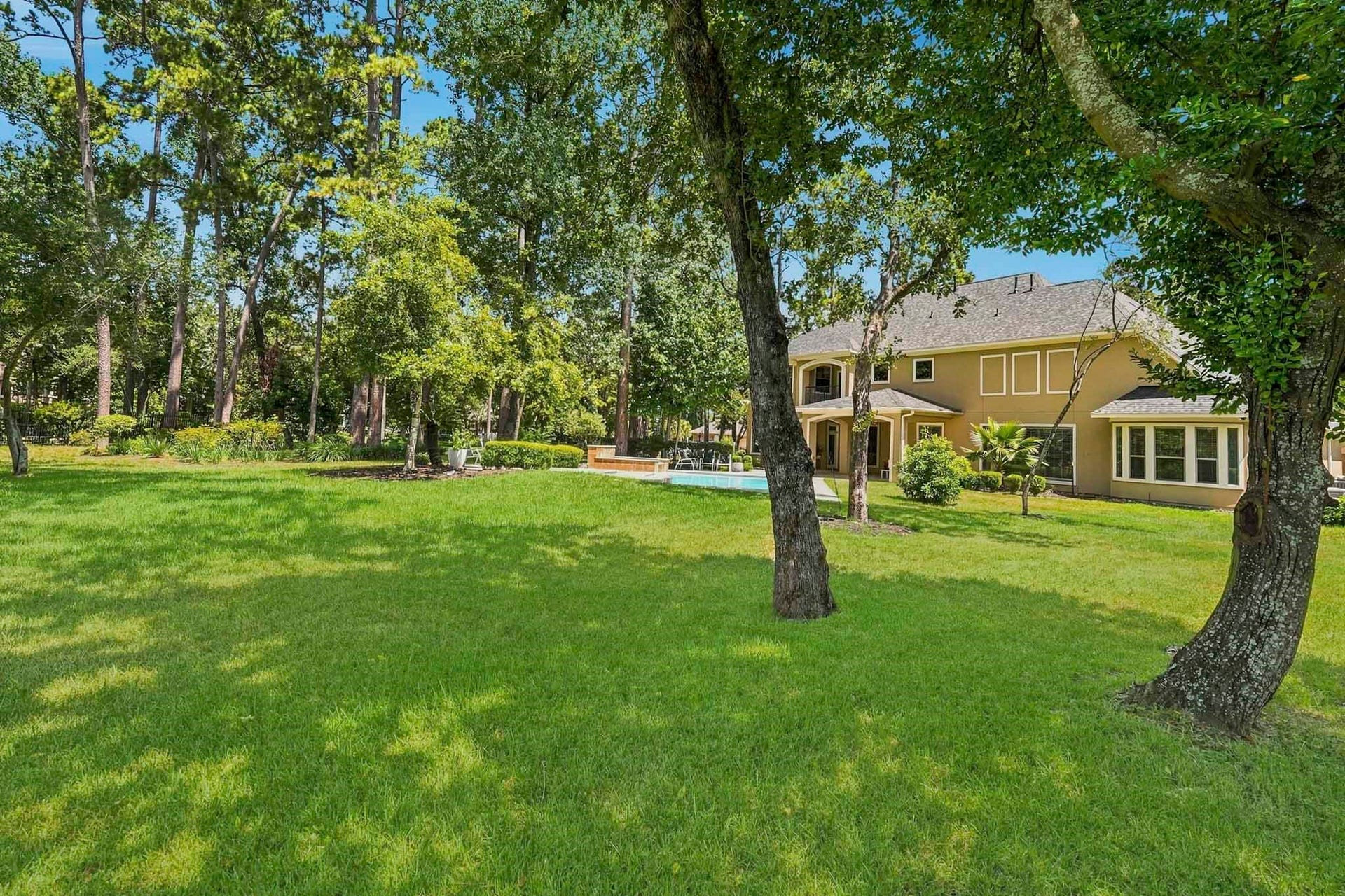 7611 Kings River Lane, Humble, TX 77346 Expansive backyard offers abundant green space surrounded by mature trees and the beauty of the property's natural setting.