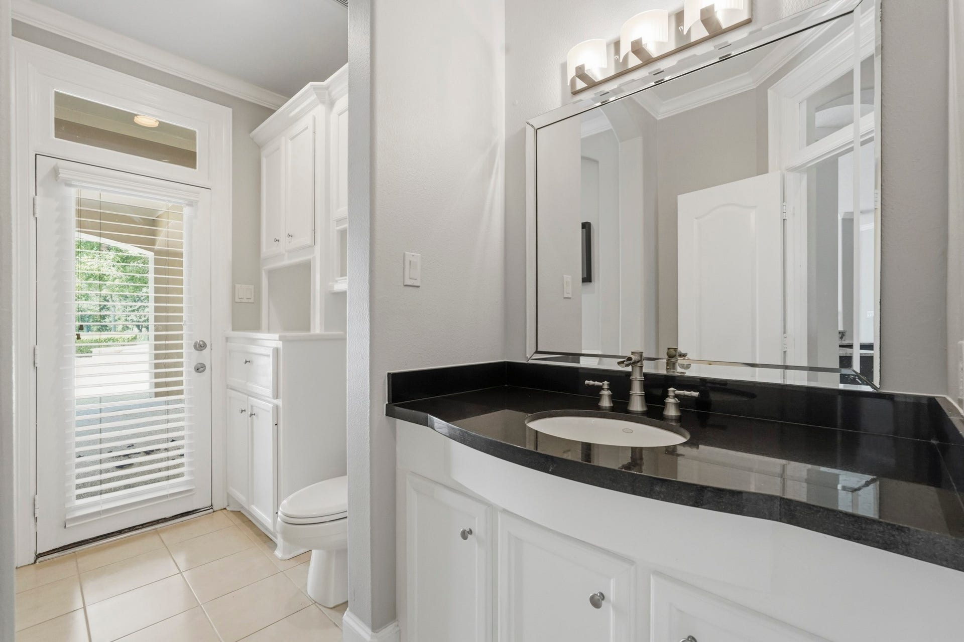 7611 Kings River Lane, Humble, TX 77346 Full guest bath features extensive cabinetry and counter space with direct exterior access to the pool area, providing added convenience for guests and outdoor entertaining.