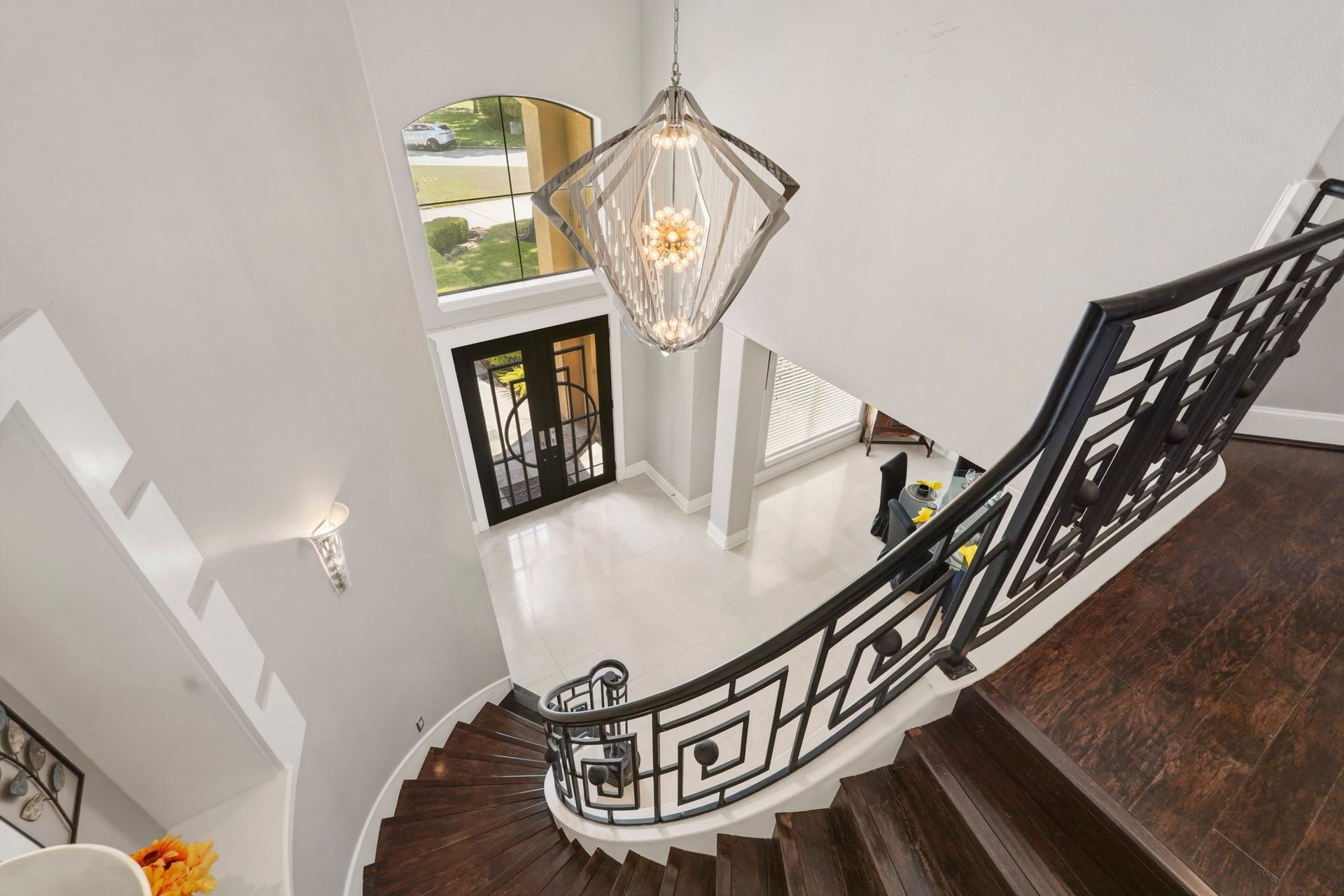 7611 Kings River Lane, Humble, TX 77346 Dramatic second-story view highlights the grand staircase, decorative iron railing, statement chandelier and soaring two-story foyer below.