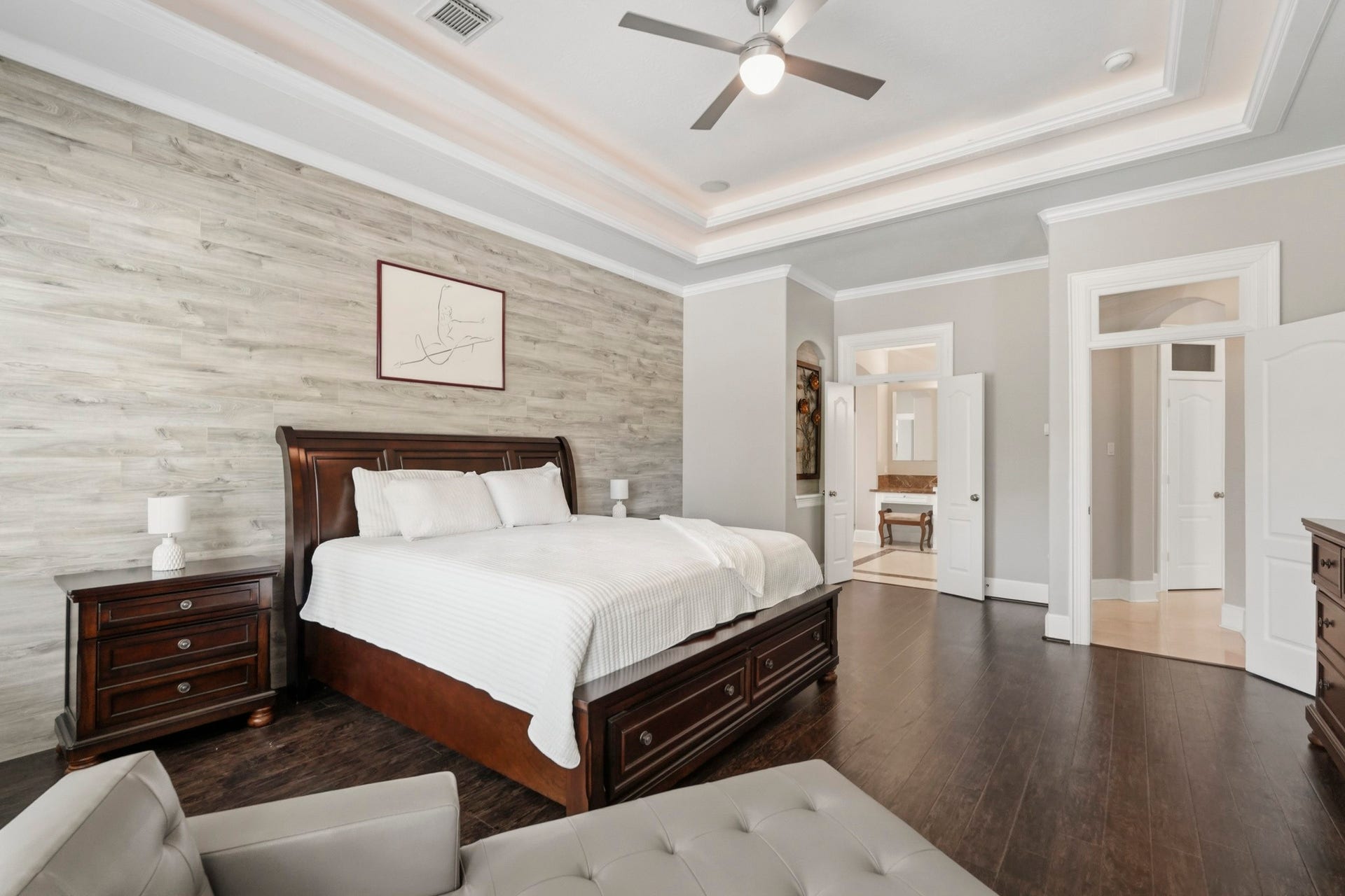 7611 Kings River Lane, Humble, TX 77346 Additional view of the primary suite highlights its impressive scale, layered ceiling treatment, crown molding, ceiling fan and beautifully finished accent wall.