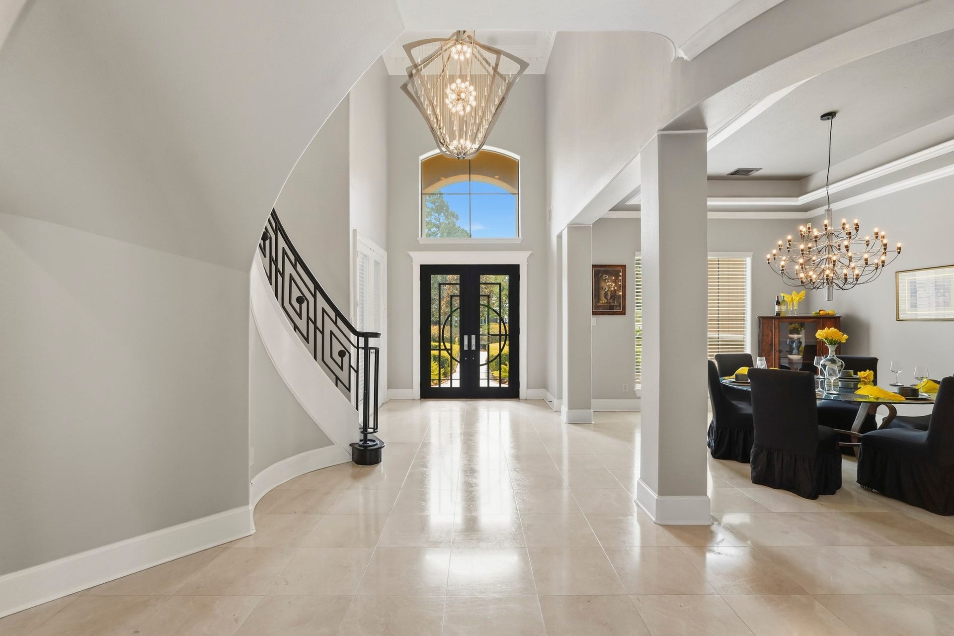 7611 Kings River Lane, Humble, TX 77346 Grand entry welcomes guests with soaring ceilings, an elegant chandelier, decorative front door, detailed millwork and polished tile flooring.