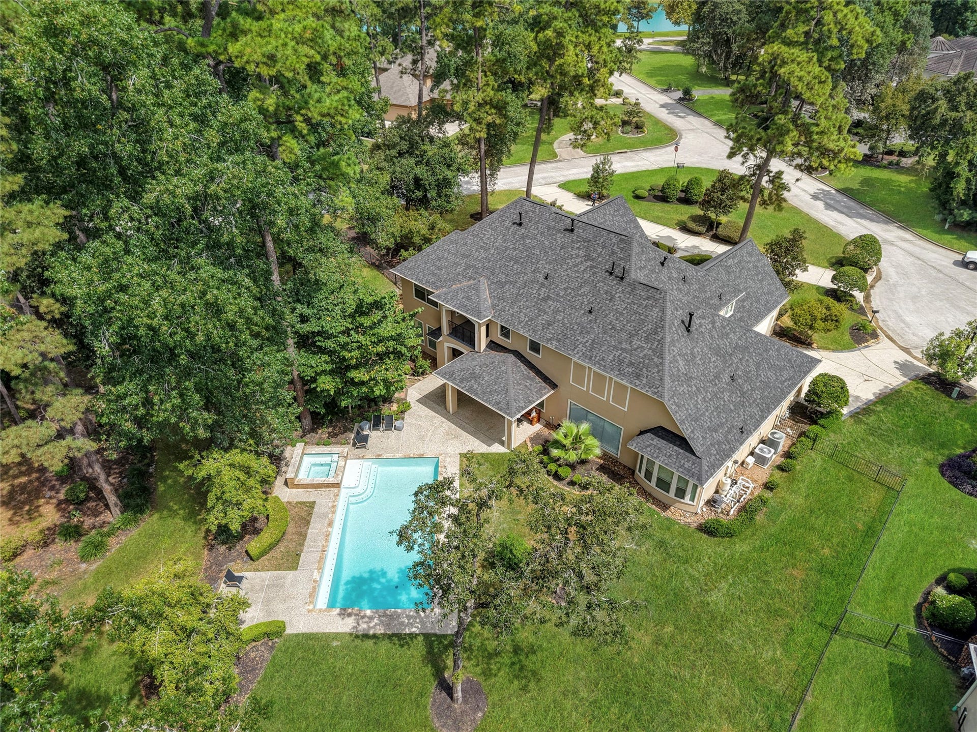 7611 Kings River Lane, Humble, TX 77346 Aerial view captures the full estate setting with the residence, pool and spa, expansive approximately 1.33-acre grounds and lakefront location.
