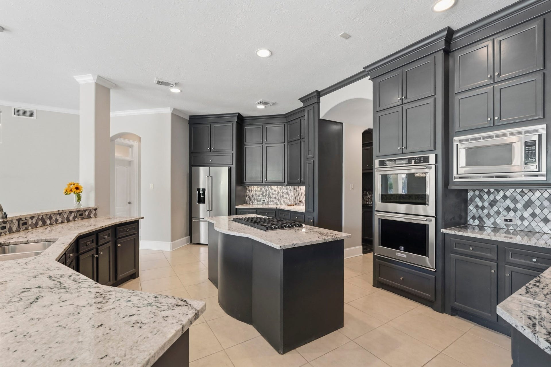 7611 Kings River Lane, Humble, TX 77346 Another view showcases the kitchen's impressive scale, extensive cabinetry and storage, large center island, abundant counter space and open layout connecting easily to the surrounding living and dining areas.