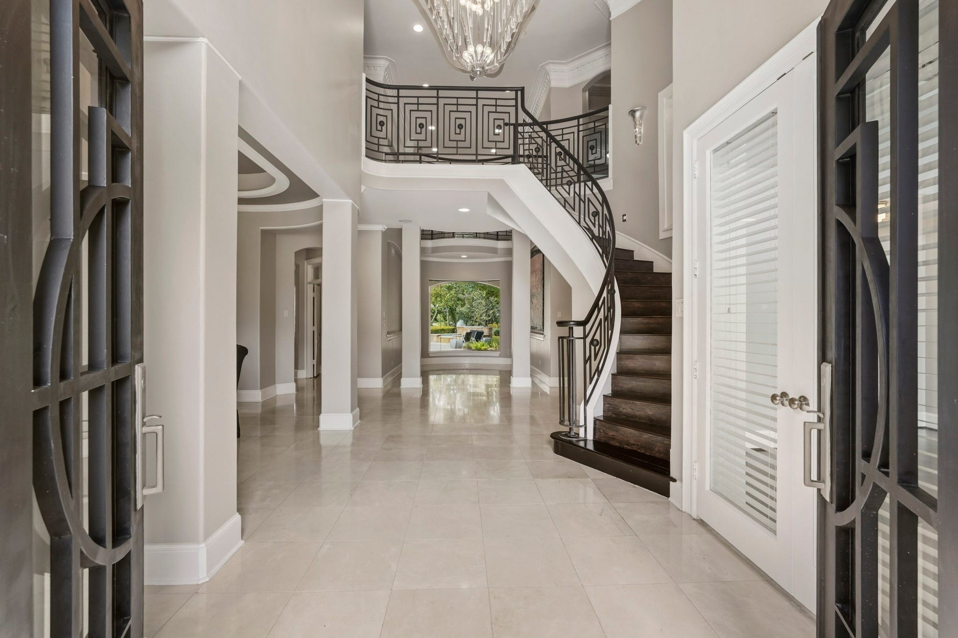 7611 Kings River Lane, Humble, TX 77346 Dramatic two-story foyer showcases the sweeping staircase with decorative iron railing, architectural columns, detailed molding and an abundance of natural light.