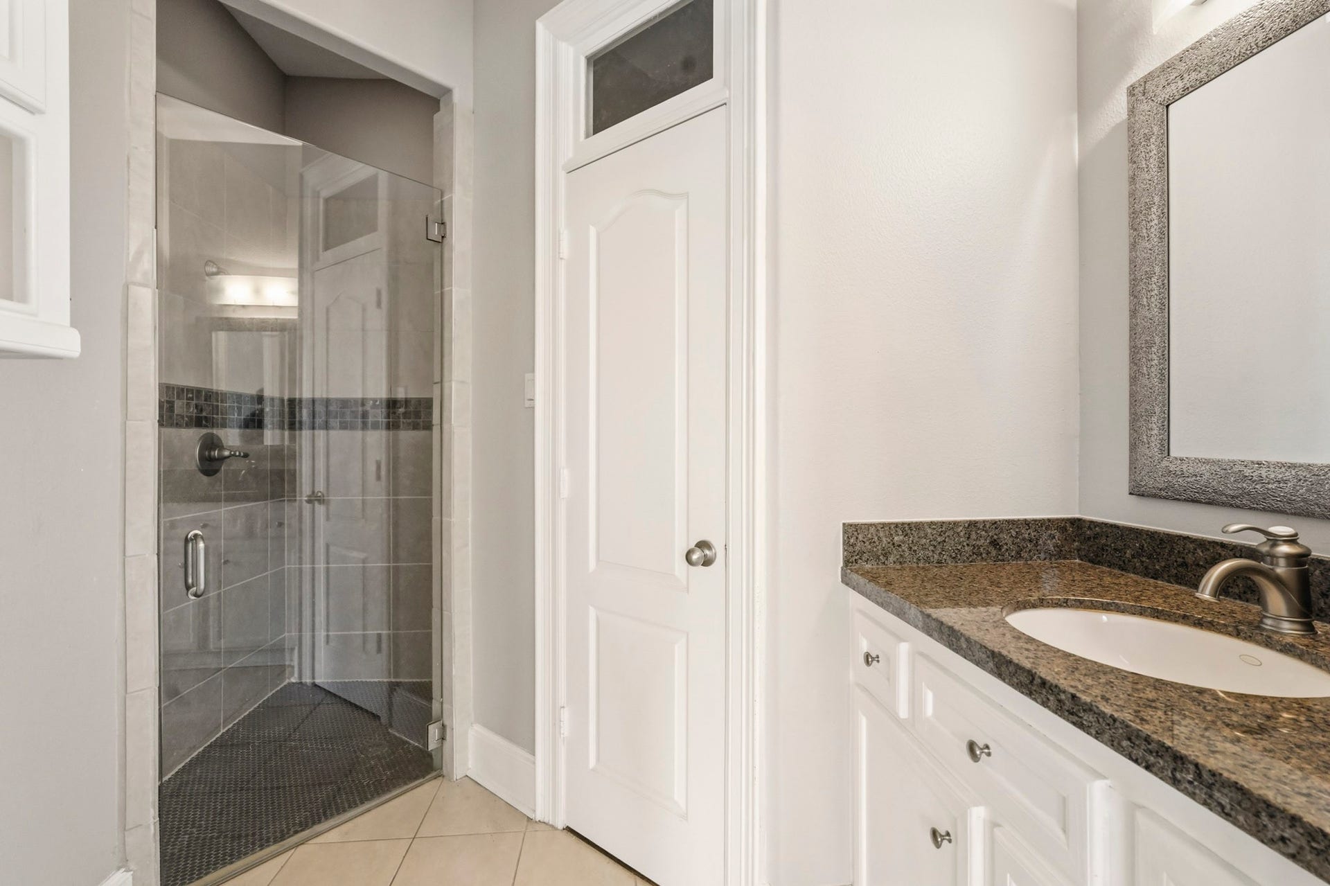7611 Kings River Lane, Humble, TX 77346 Private en-suite bath serving the downstairs bedroom features a granite countertop, vanity storage and separate shower.