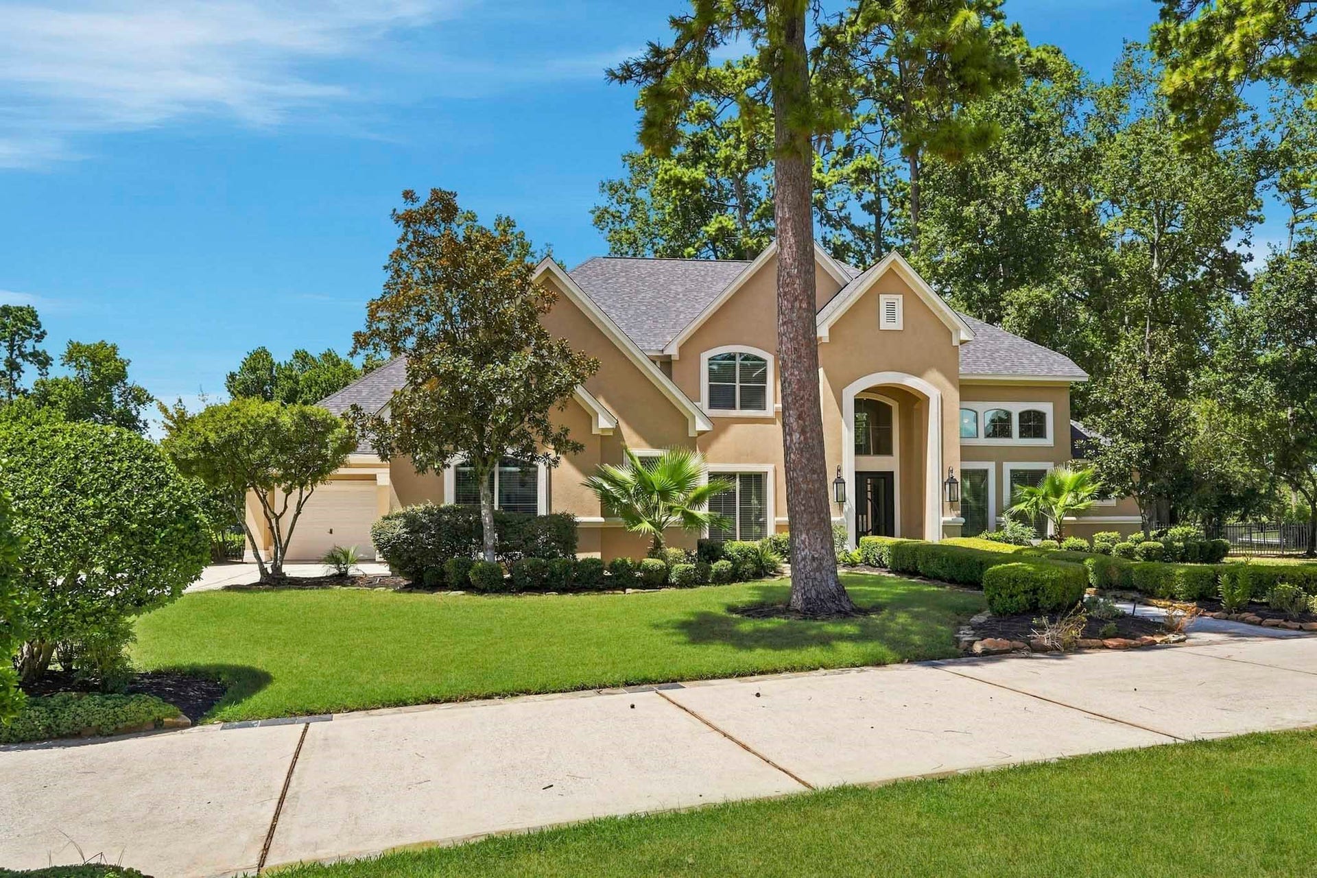 7611 Kings River Lane, Humble, TX 77346 Stately two-story residence framed by mature trees and manicured landscaping, creating an impressive first impression in gated Kings River Estates.