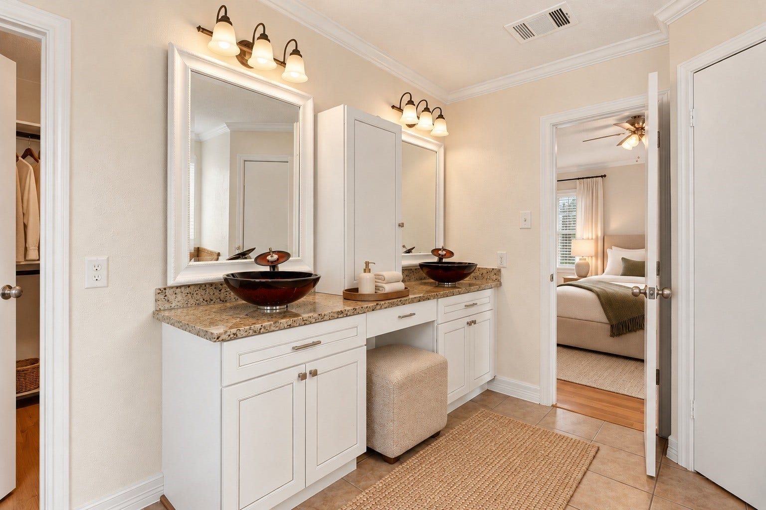 Another view of the spacious primary bathroom featuring a double vanity with granite countertops, distinctive vessel sinks, elegant framed mirrors, and white cabinetry. A dedicated makeup vanity area adds convenience and functionality, creating a comfortable space for everyday routines.letters
VIRTUAL STAGING