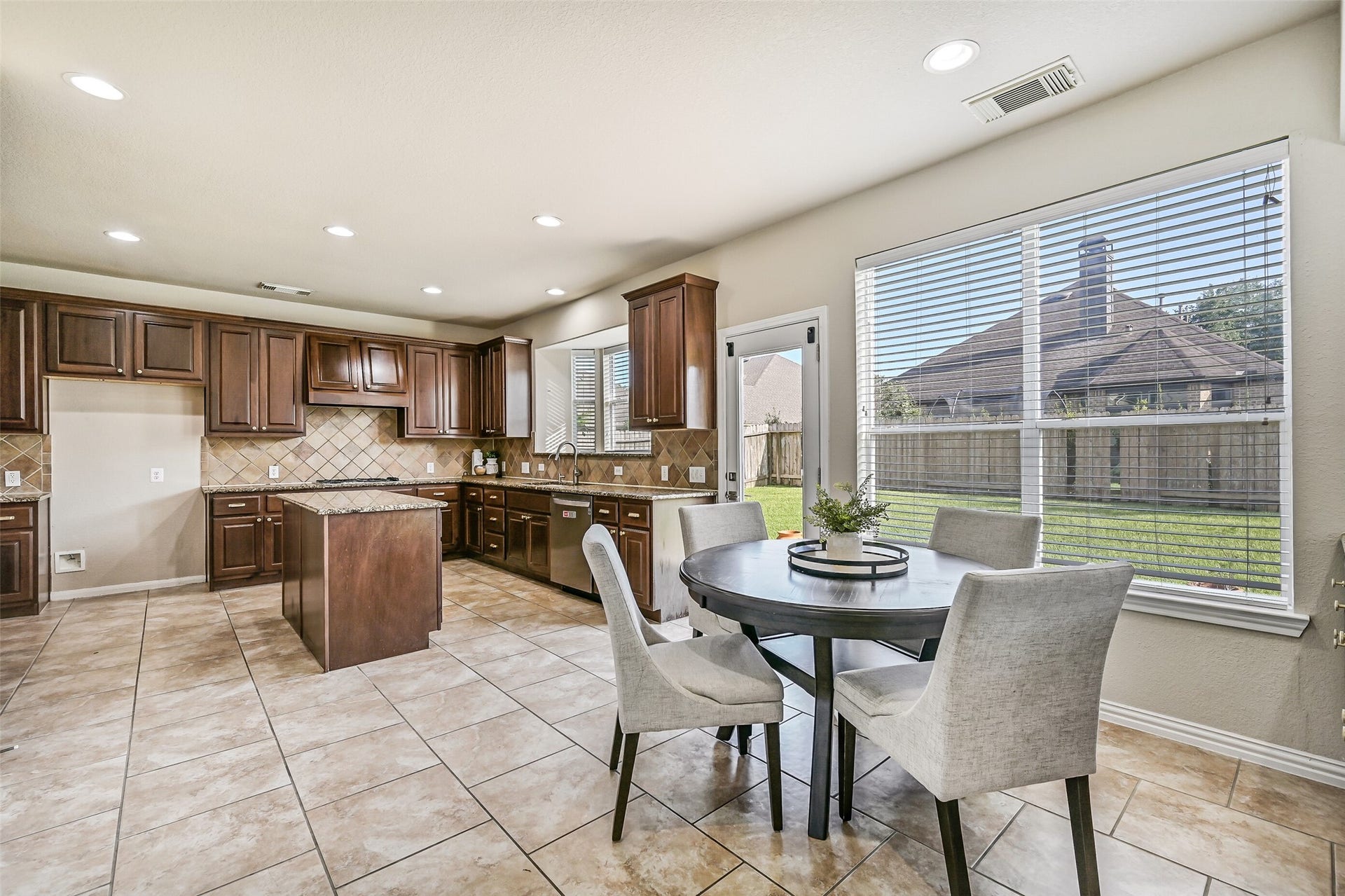 2508 Rockygate Lane, Friendswood, TX 77546 Just beyond the kitchen, the sunlit breakfast room offers a casual dining space wrapped in windows overlooking the backyard. A built-in granite-topped buffet provides extra storage and serving space, making it equally convenient for everyday meals and entertaining guests.
