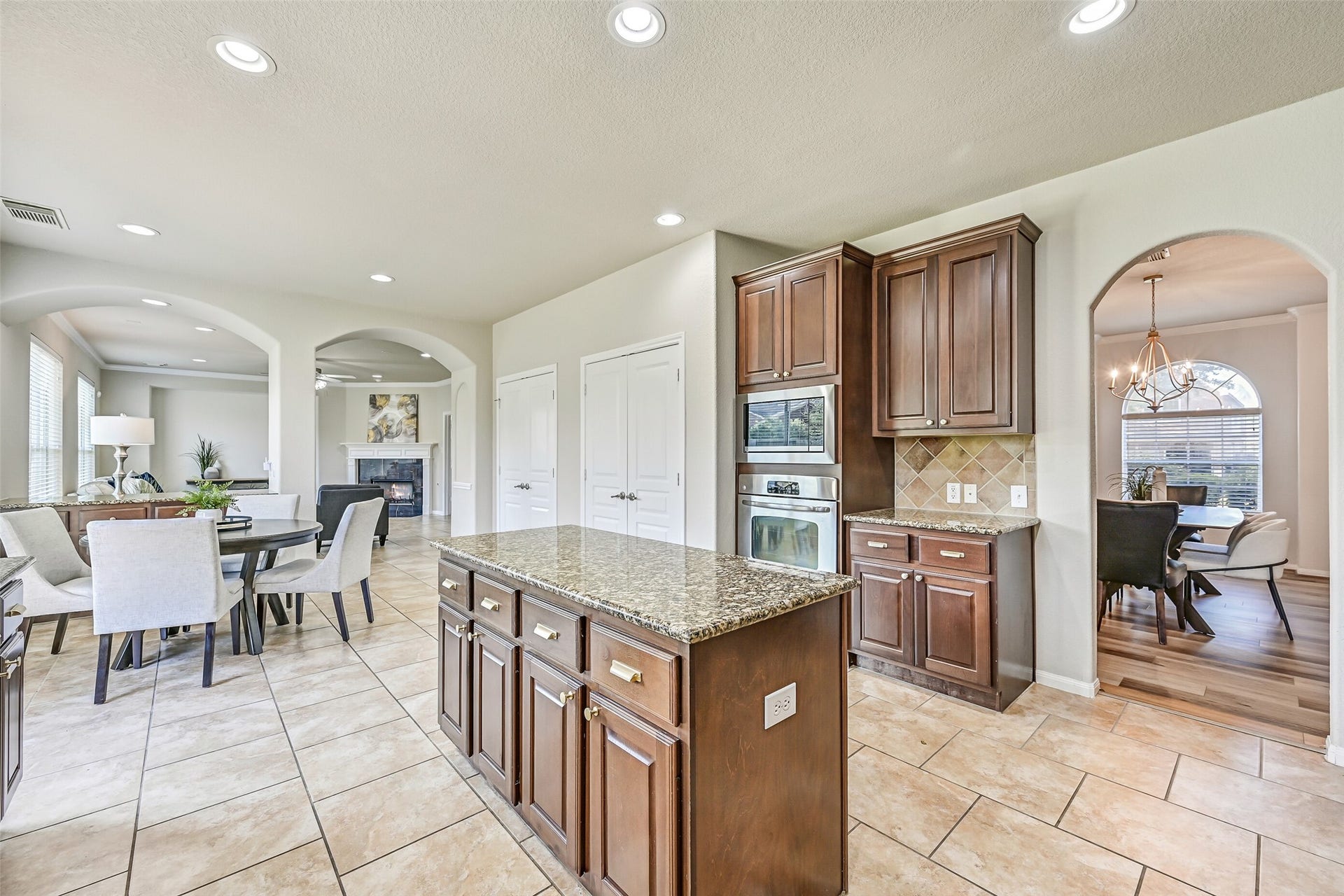 2508 Rockygate Lane, Friendswood, TX 77546 From this angle, appreciate the kitchen's generous footprint and exceptional storage options. Stainless built-in appliances, extensive cabinetry, and not one but two oversized double-door pantries make organization effortless, while the open flow keeps you connected to both the breakfast area and family room.